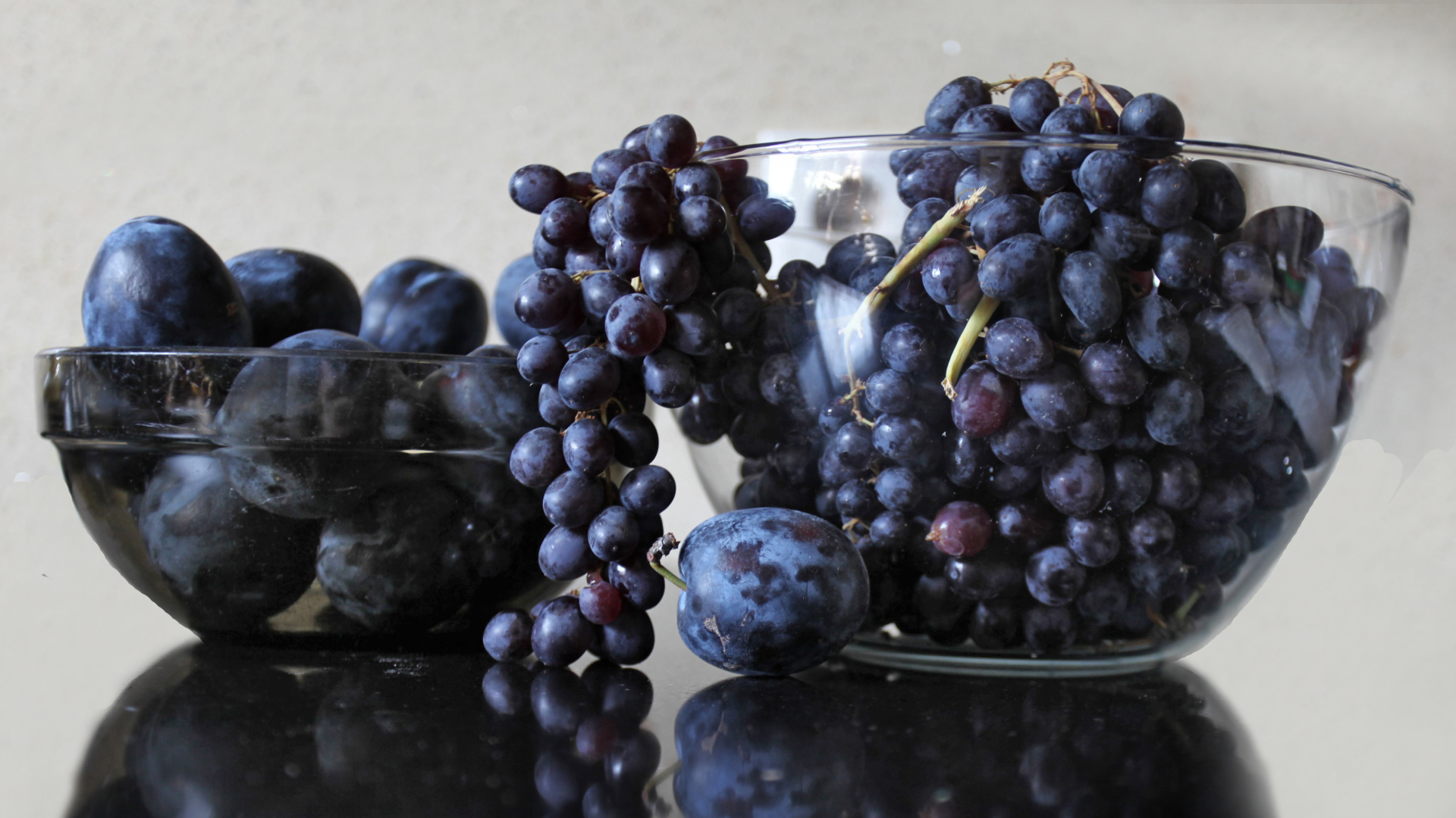 Синий виноград с синими сливами на столе