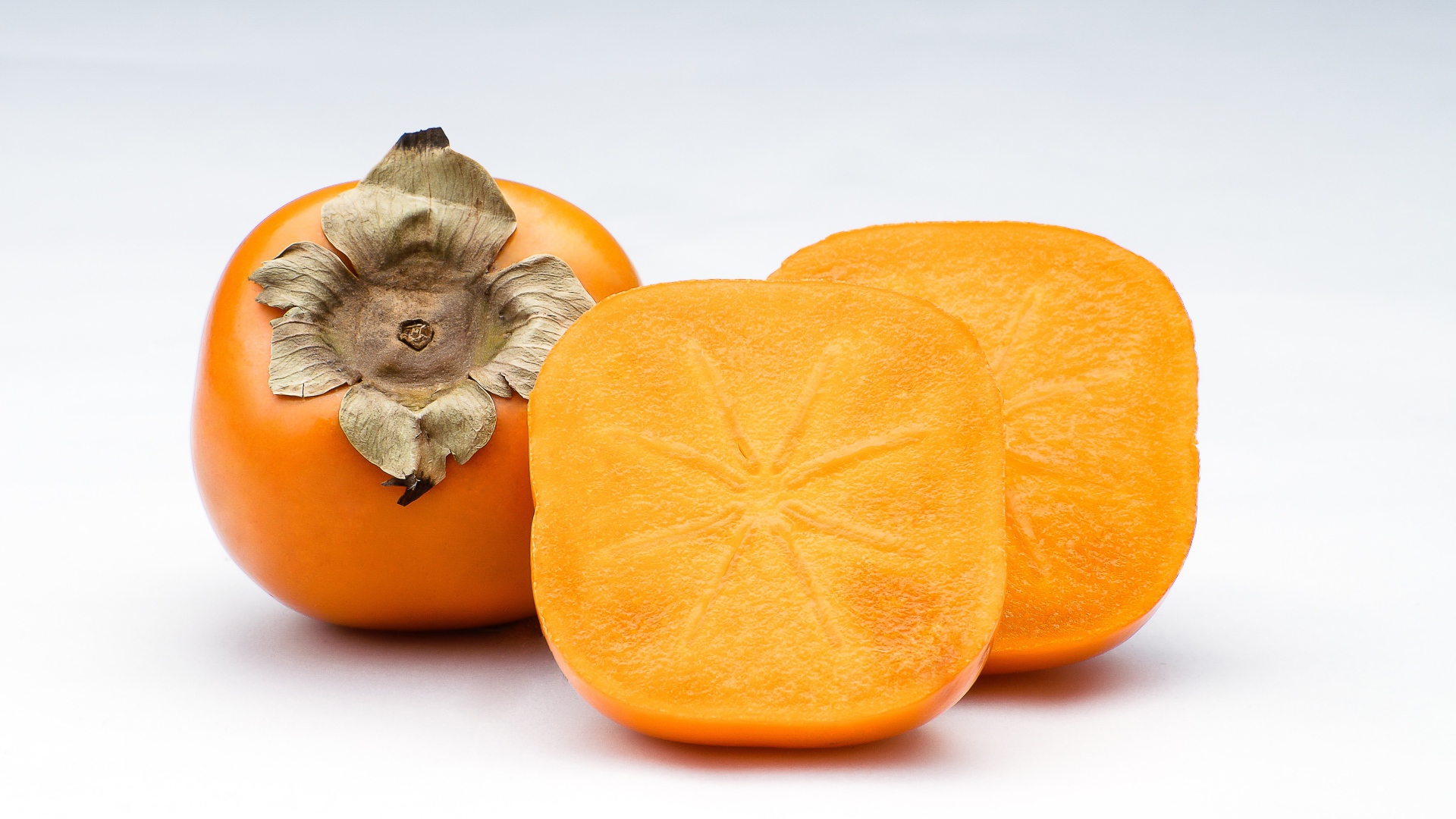 Оранжевая хурма на сером фоне крупным планом