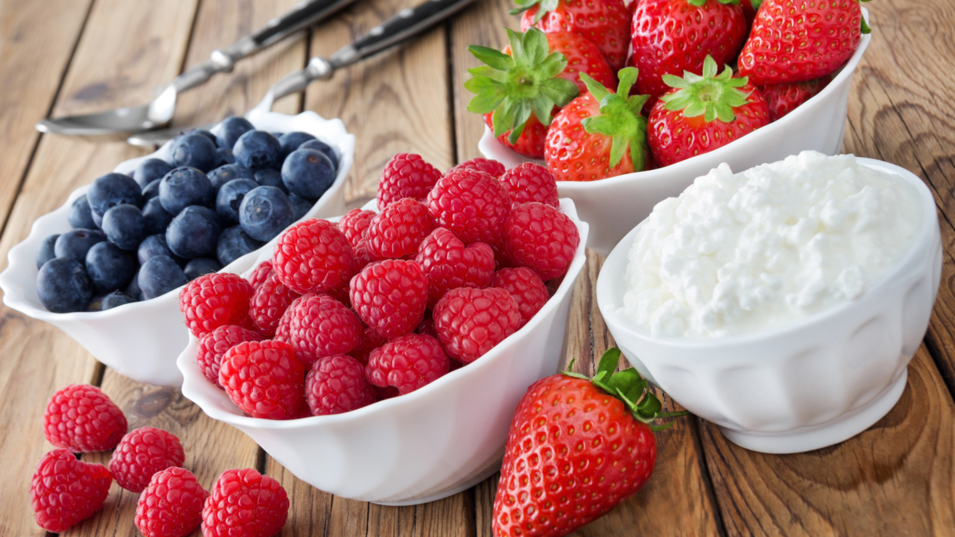 Ягоды малины, черники и клубники на столе с творогом