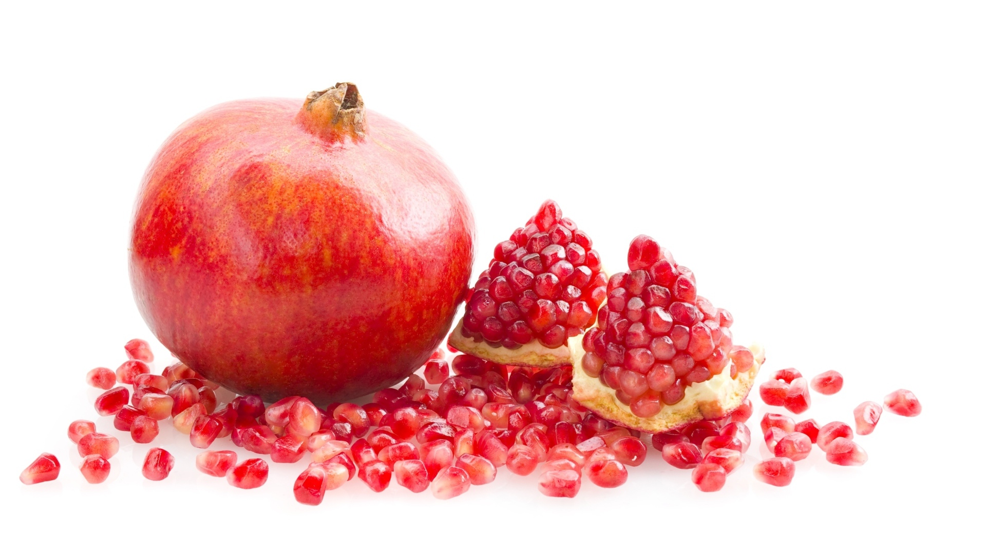 Красный гранат с зернами на белом фоне