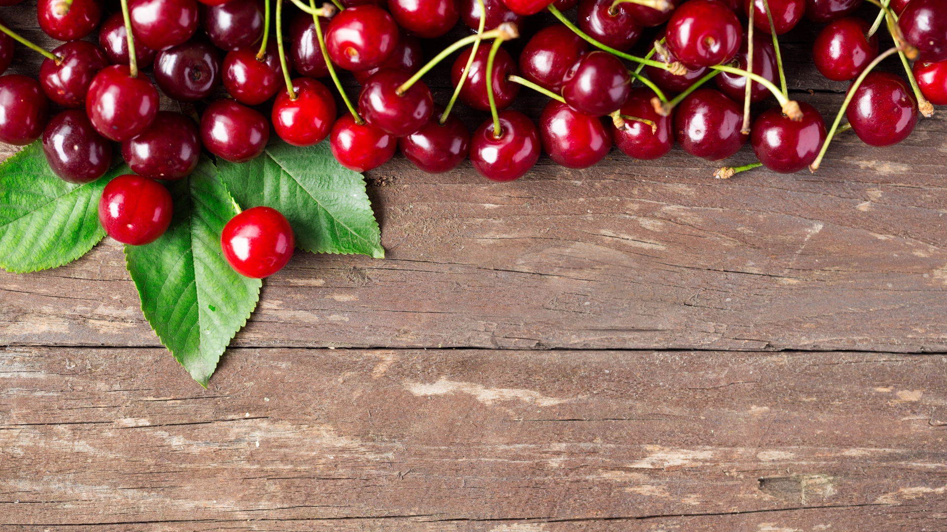 Красные спелые вишни на деревянном столе