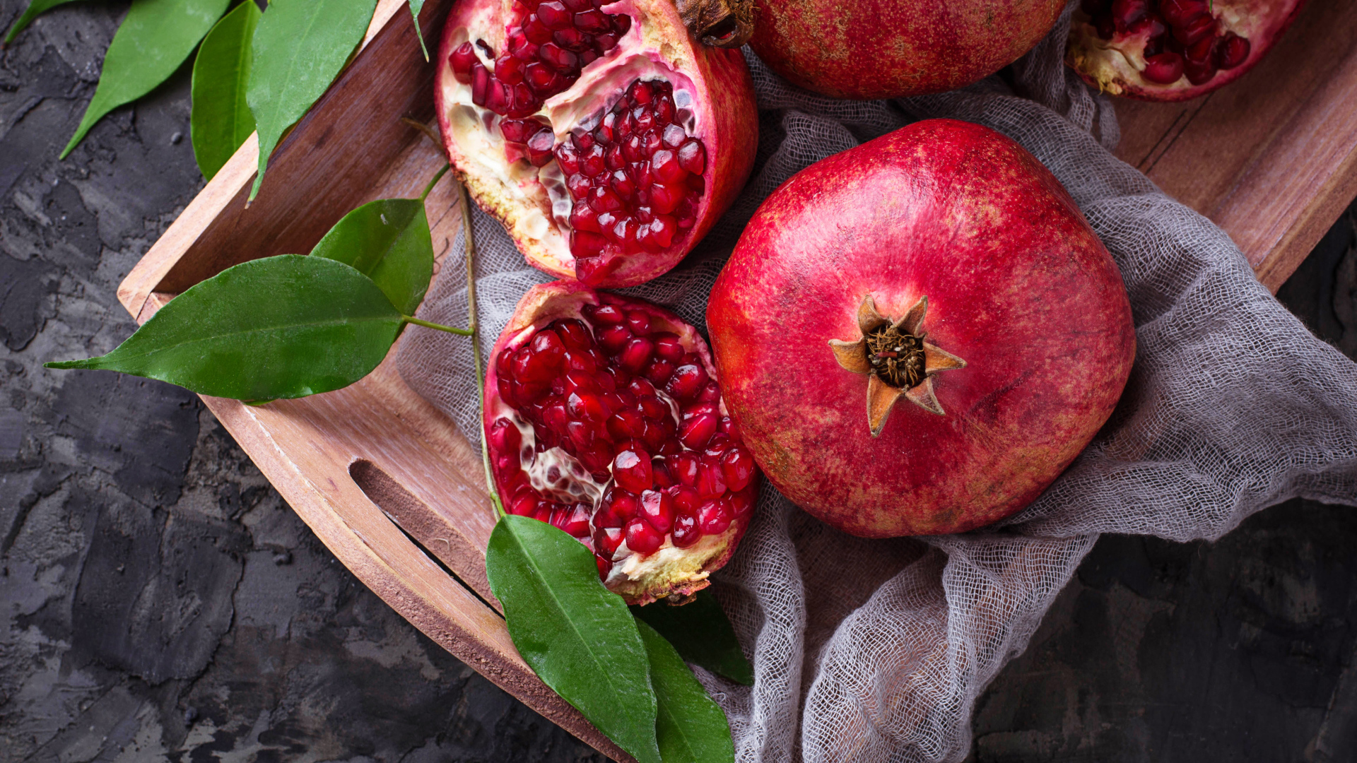 Спелые красные гранаты в деревянном ящике