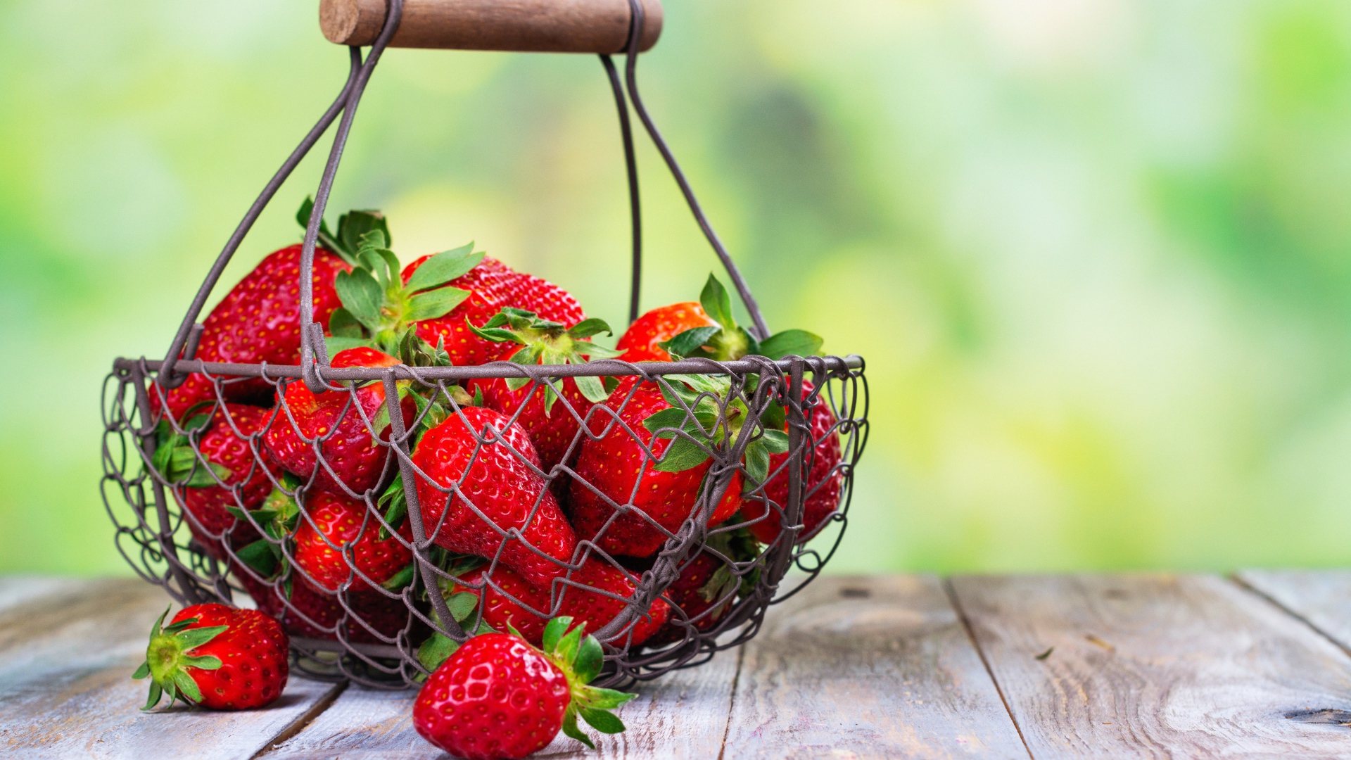 Спелая красная клубника в корзине на столе