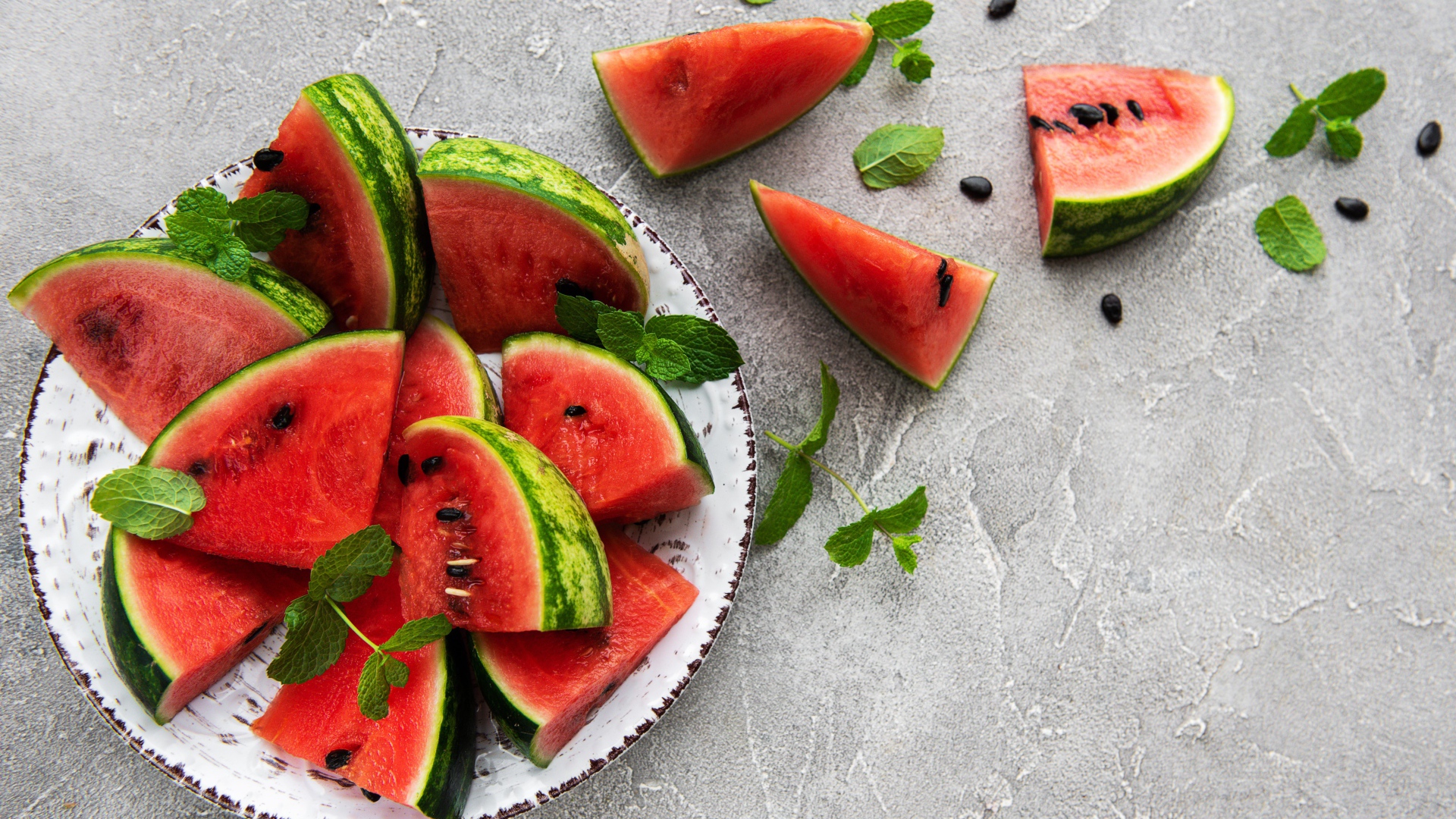 Полосатый арбуз нарезан кусочками на тарелке