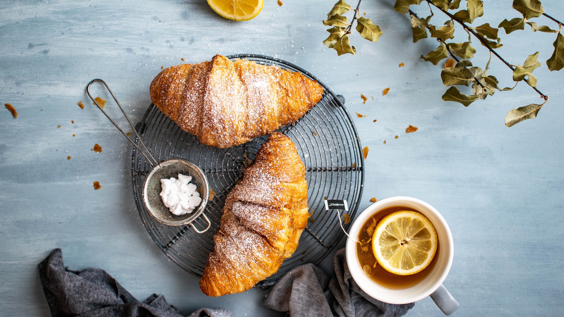 Два свежих круассана на столе с чаем