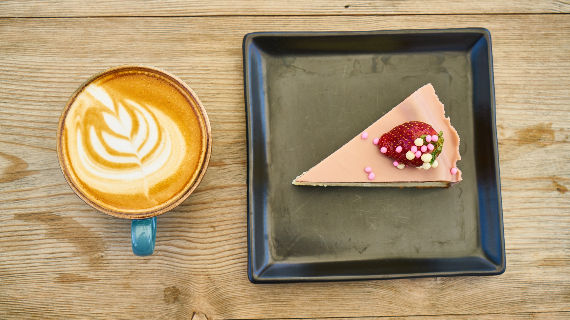 Кусок торта на черной тарелке с кофе