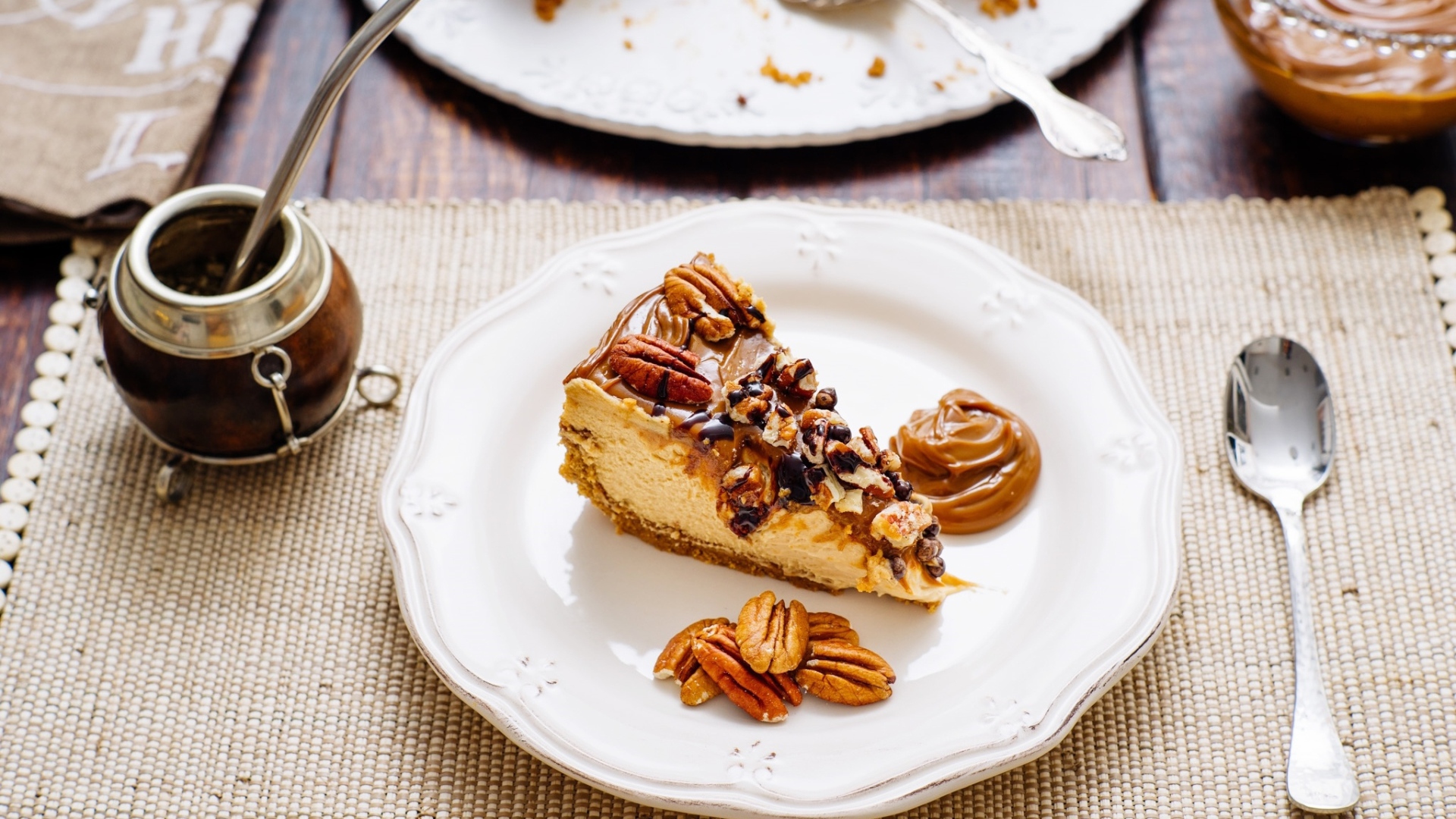 Кусок торта с орехами на белой тарелке на столе с кофе