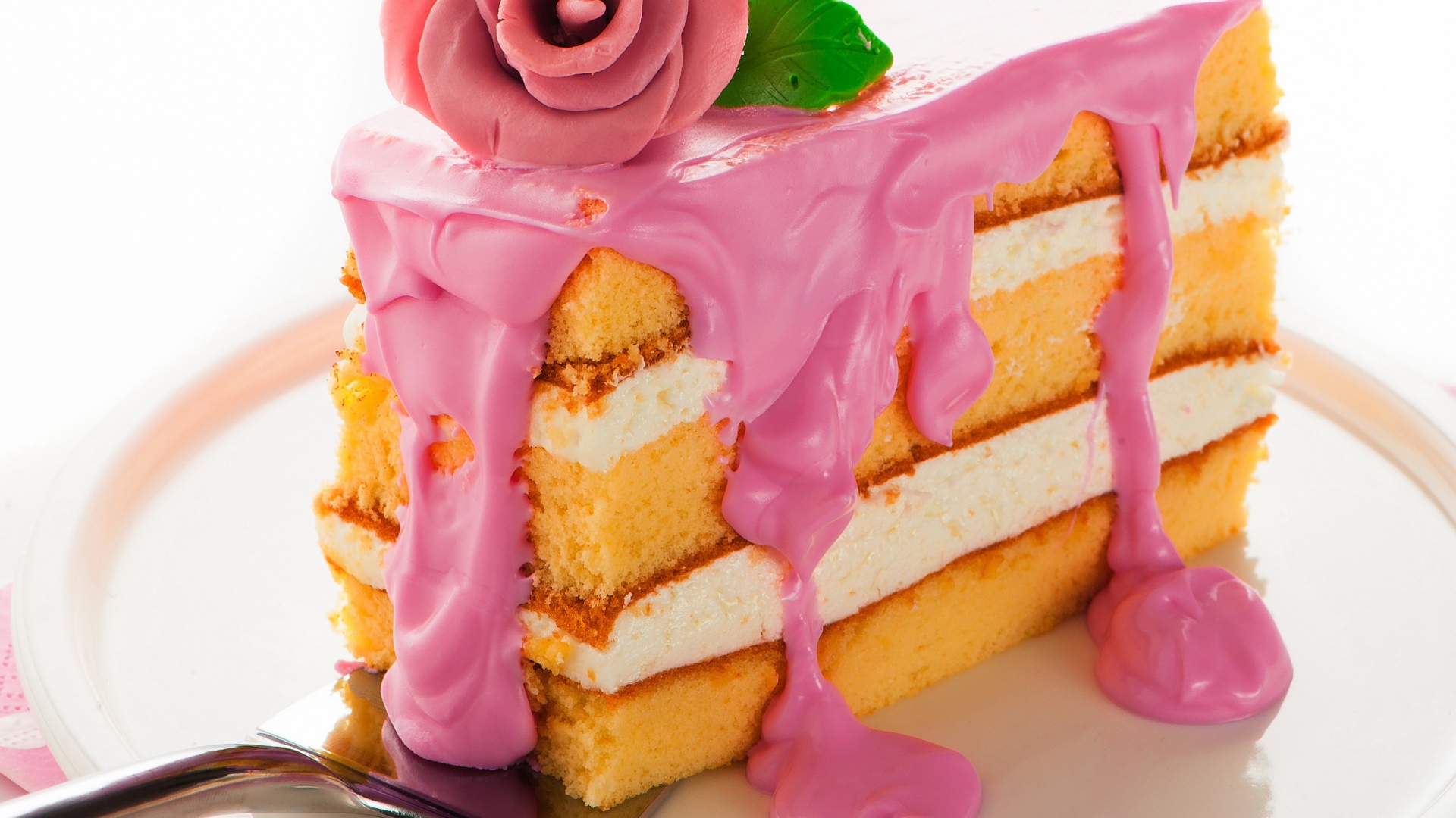 Кусок торта с розовым кремом и сахарном розой
