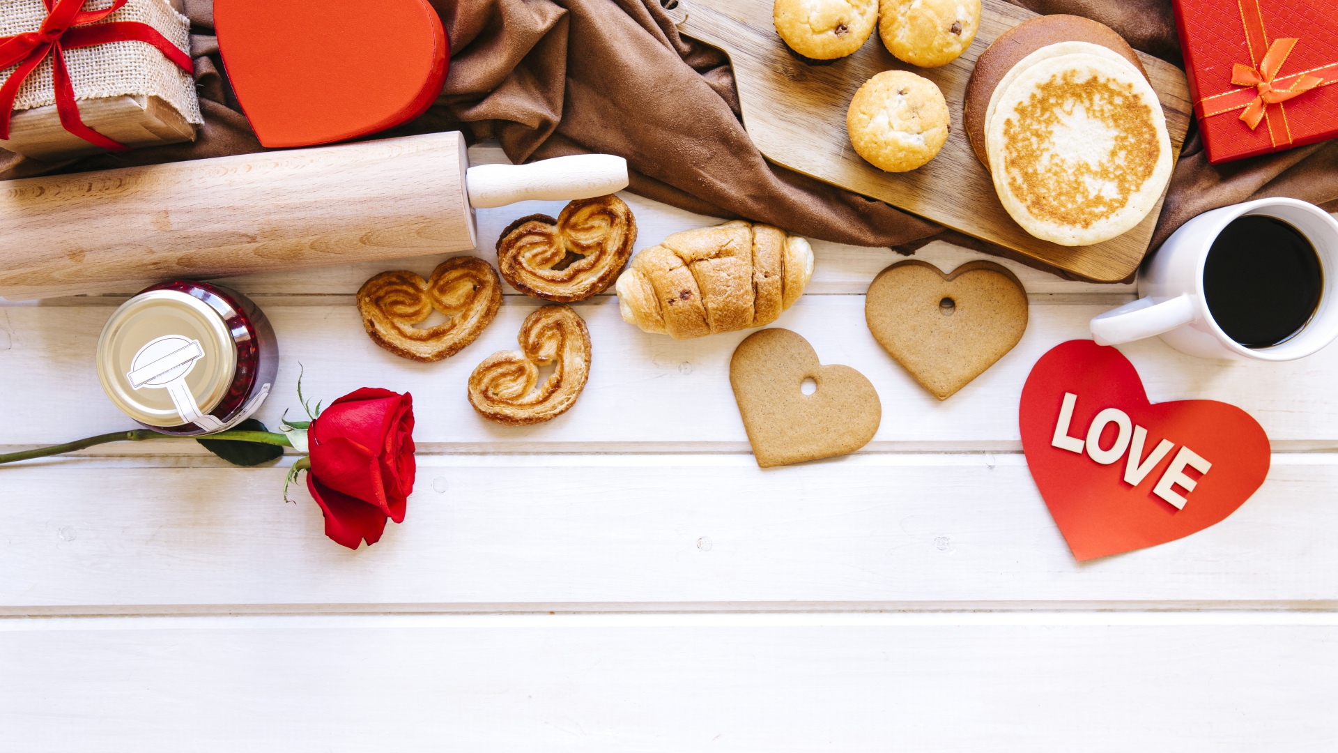 Аппетитная сладкая выпечка на столе с кофе, сердечками и подарками 