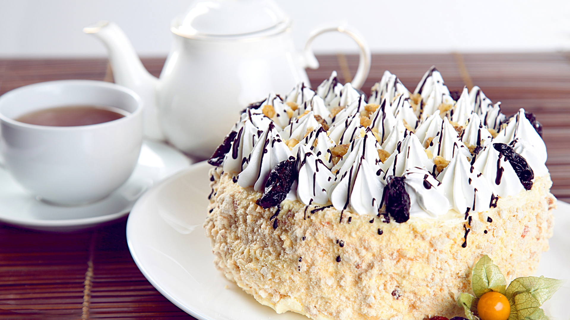 Красивый праздничный торт с безе на столе с чаем