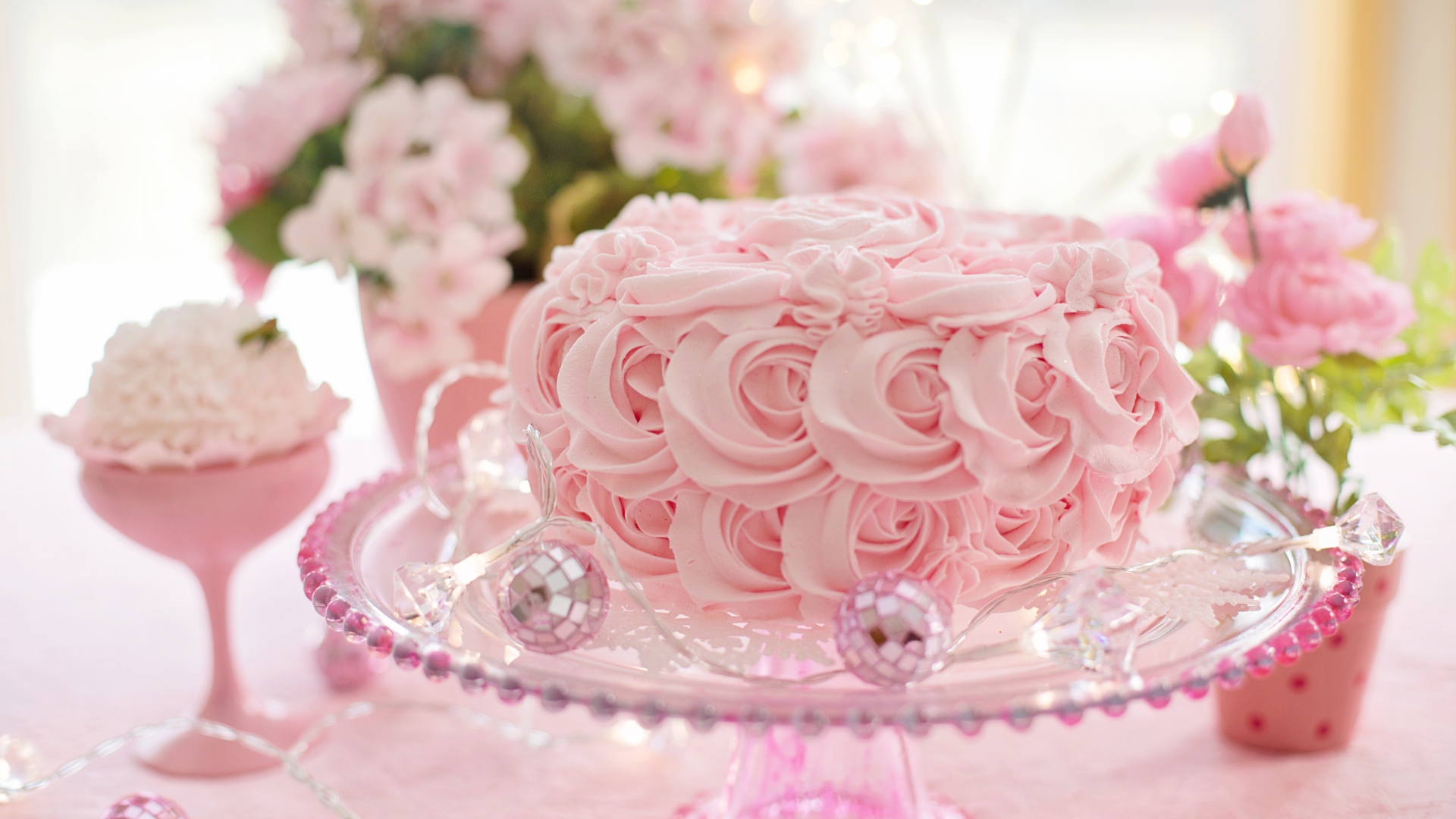 Красивый розовый торт на столе с цветами