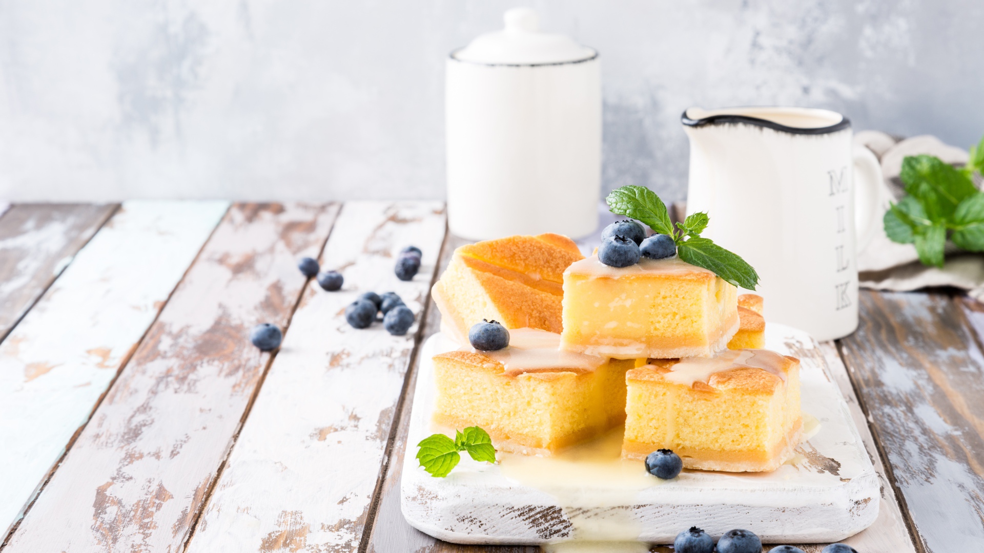 Кусочки бисквитного пирожного на столе с ягодами черники