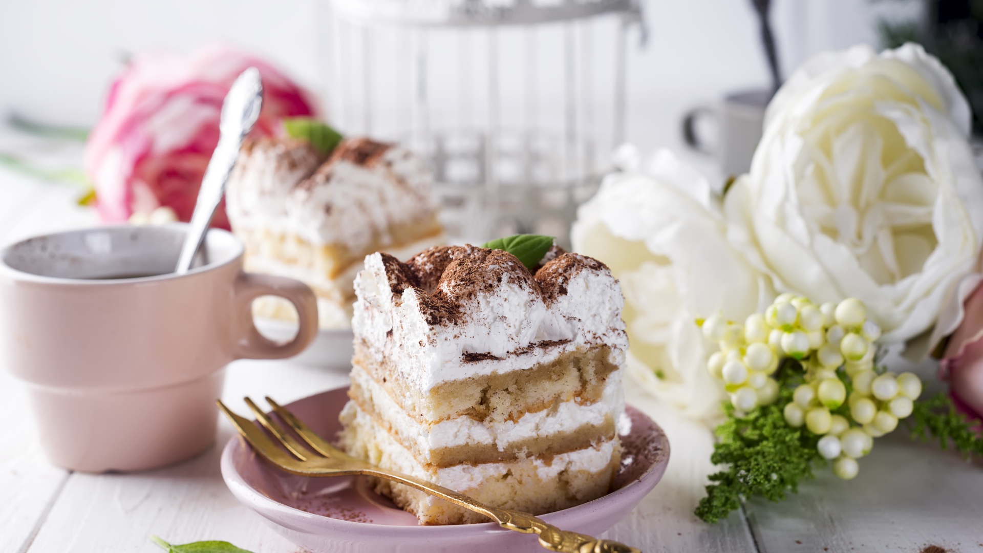 Пирожное на столе с кофе и цветами 