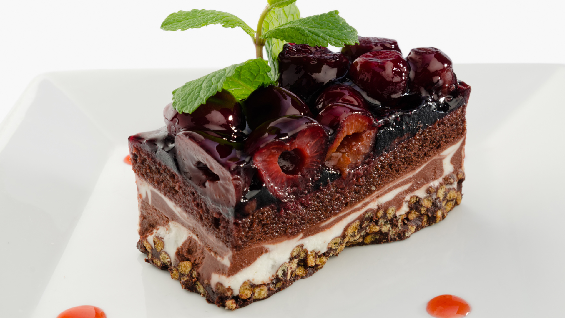 Пирожное с черешней и листиками мяты на сером фоне