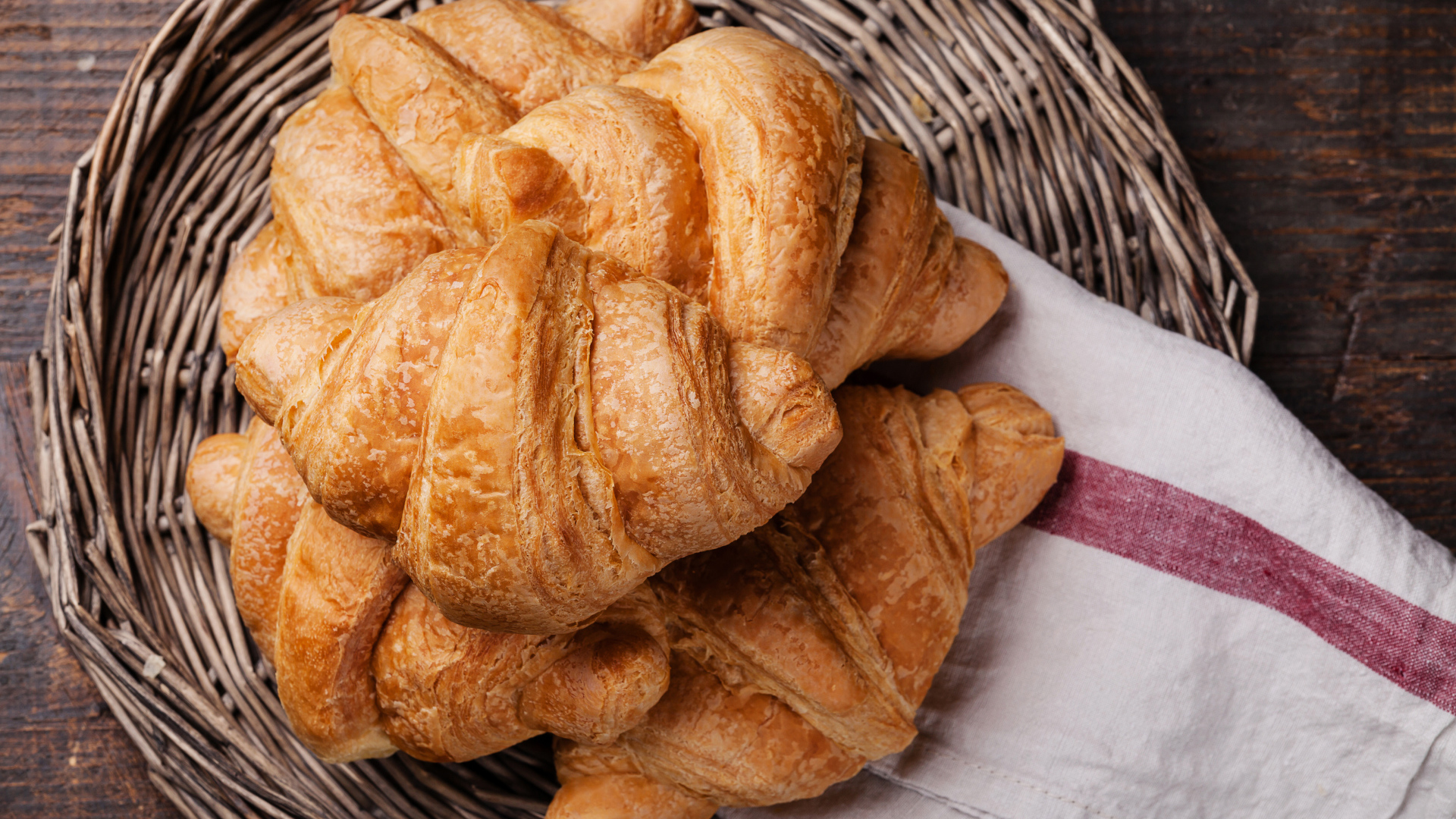 Свежие круассаны в корзинке с полотенцем