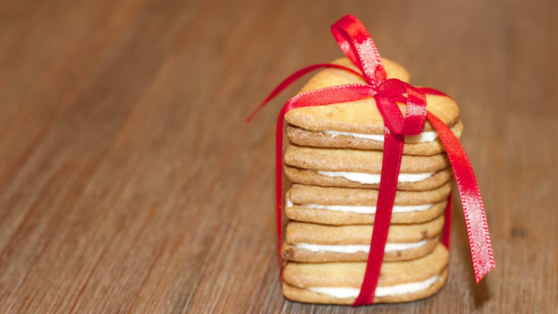 Печенье в форме сердца перевязано красной лентой 