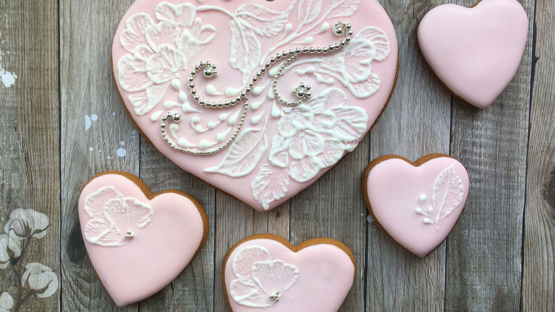 Печенье в форме сердца с розовой глазурью на столе