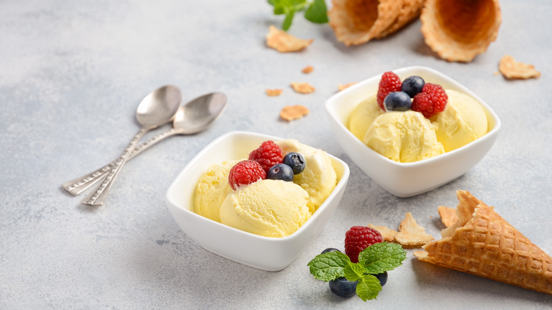 Шарики мороженого с ягодами на столе с вафельными рожками