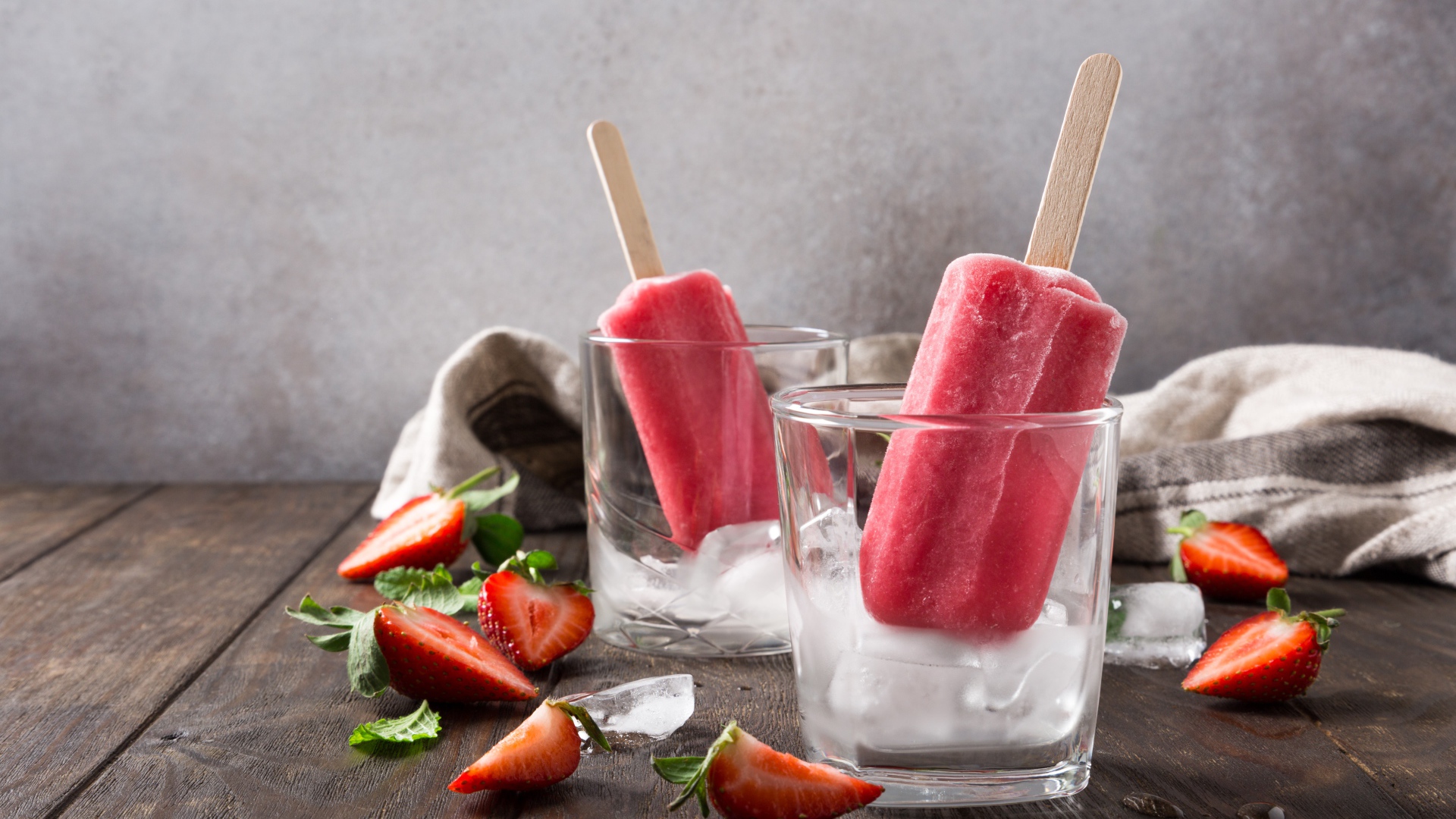 Фруктовое мороженое в стакане со льдом на столе с клубникой