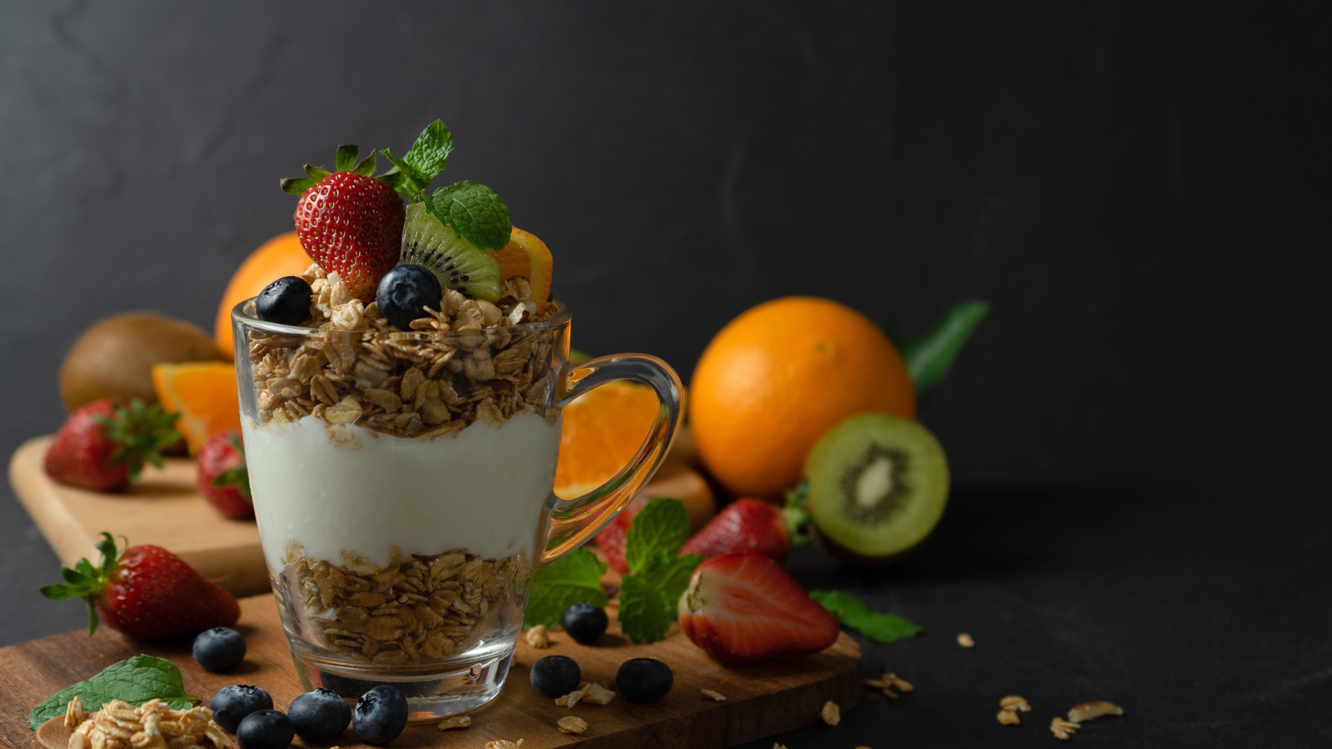 Овсяные хлопья с чашке с йогуртом на столе с ягодами и фруктами