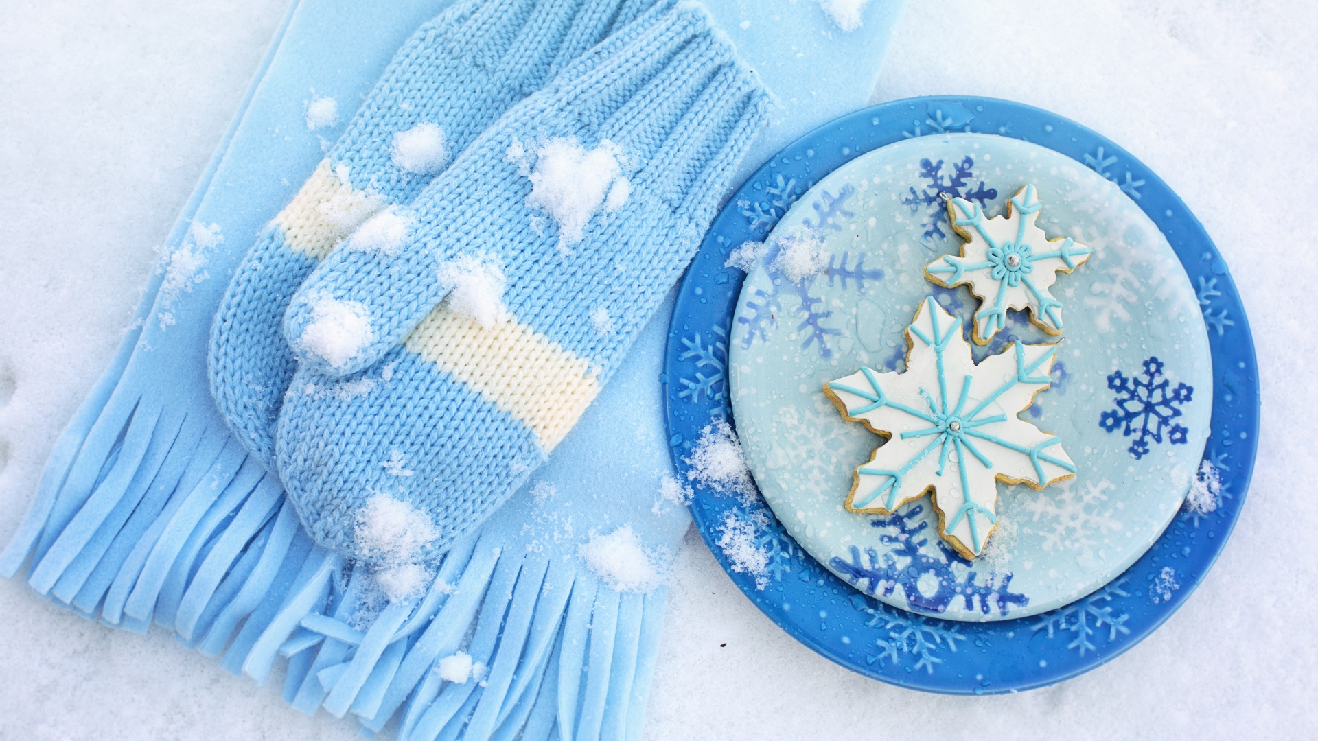 Печенье снежинки на снегу с шарфом и рукавицами