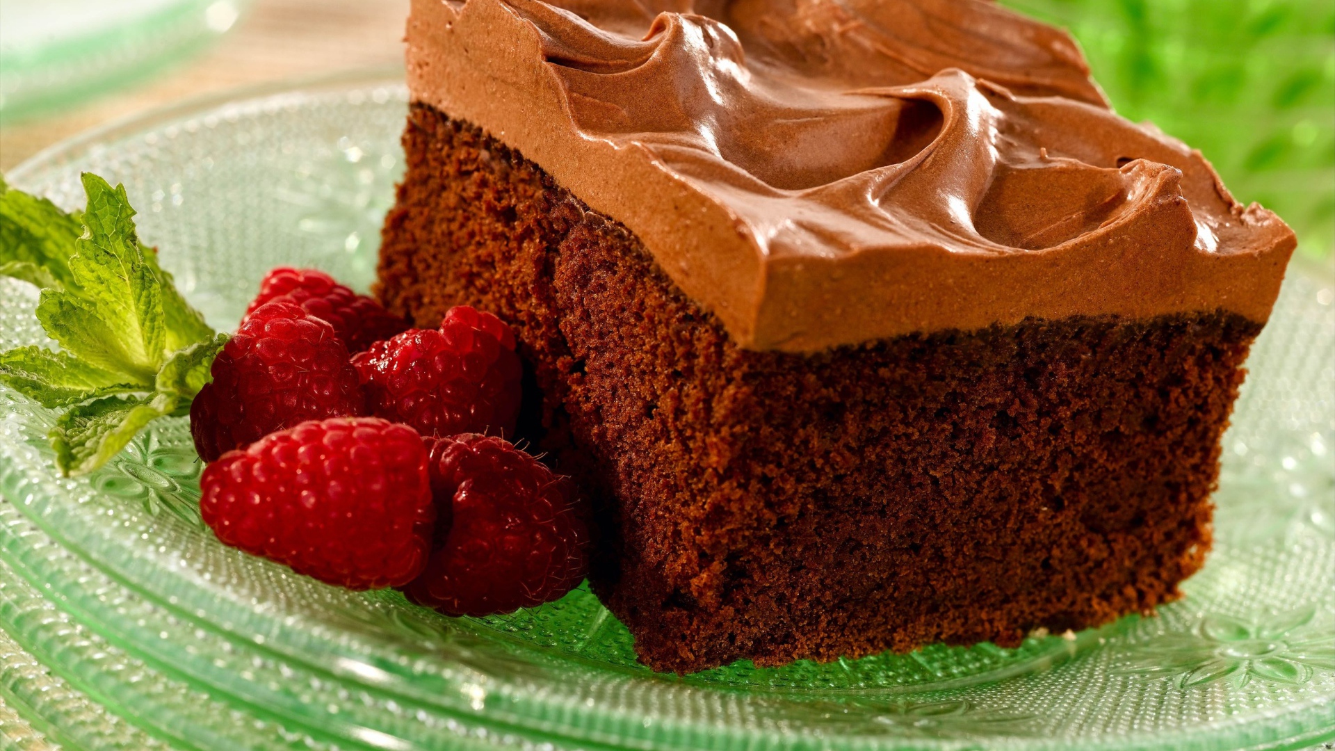 Бисквит с кремом и свежей малиной на тарелке