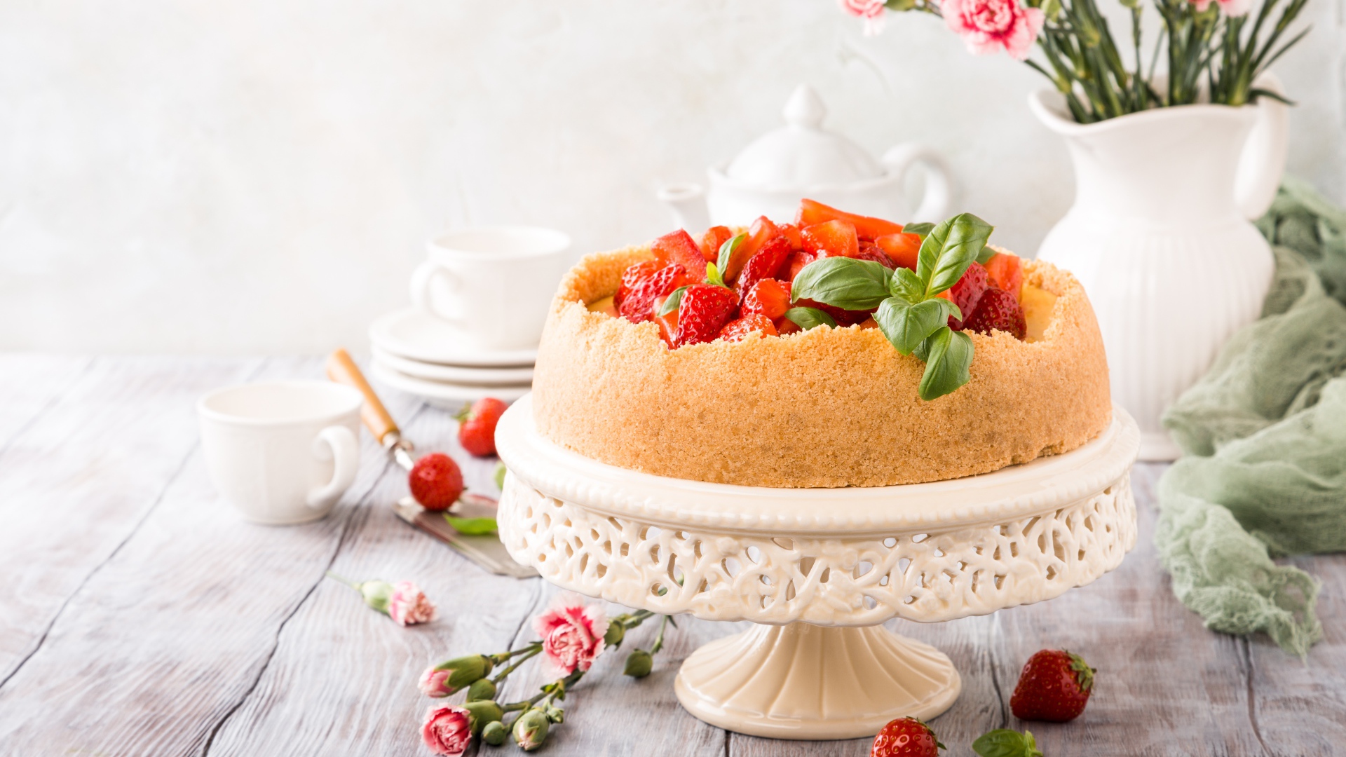 Песочный пирог с клубникой на столе с цветами гвоздики