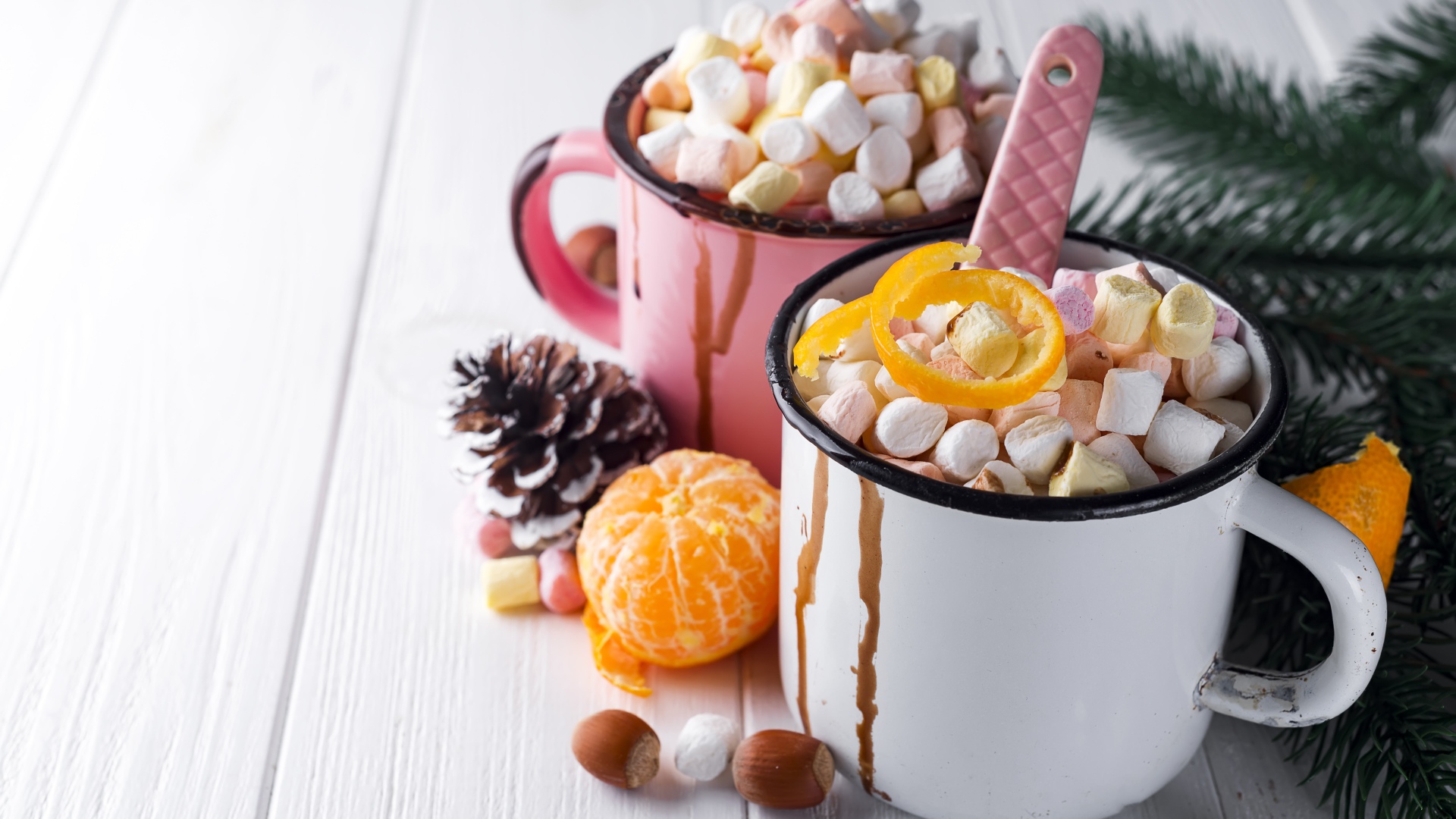 Две железные кружки с маршмеллоу на столе 