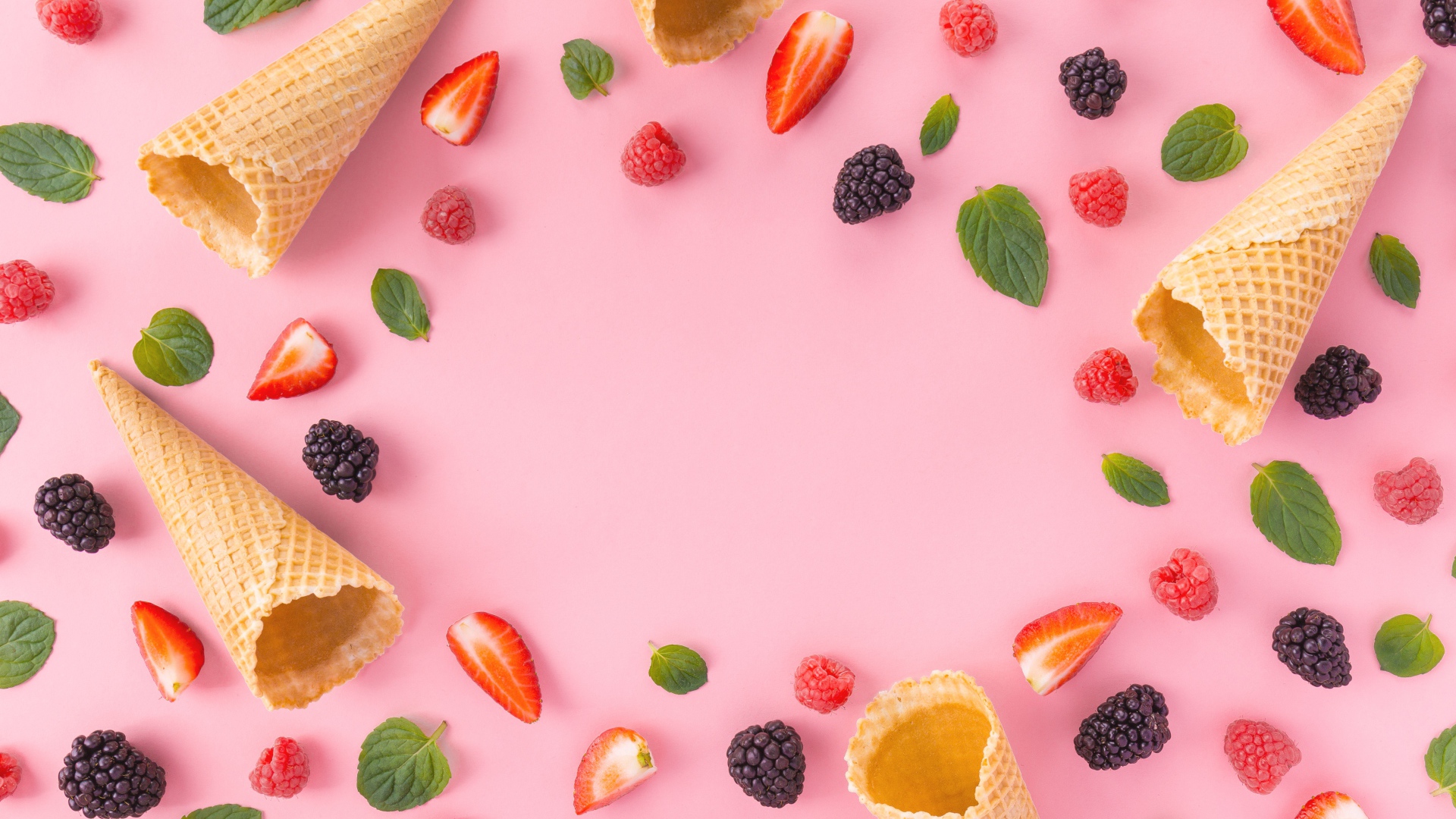 Вафельные рожки на розовом фоне с ягодами малины, клубники и ежевики