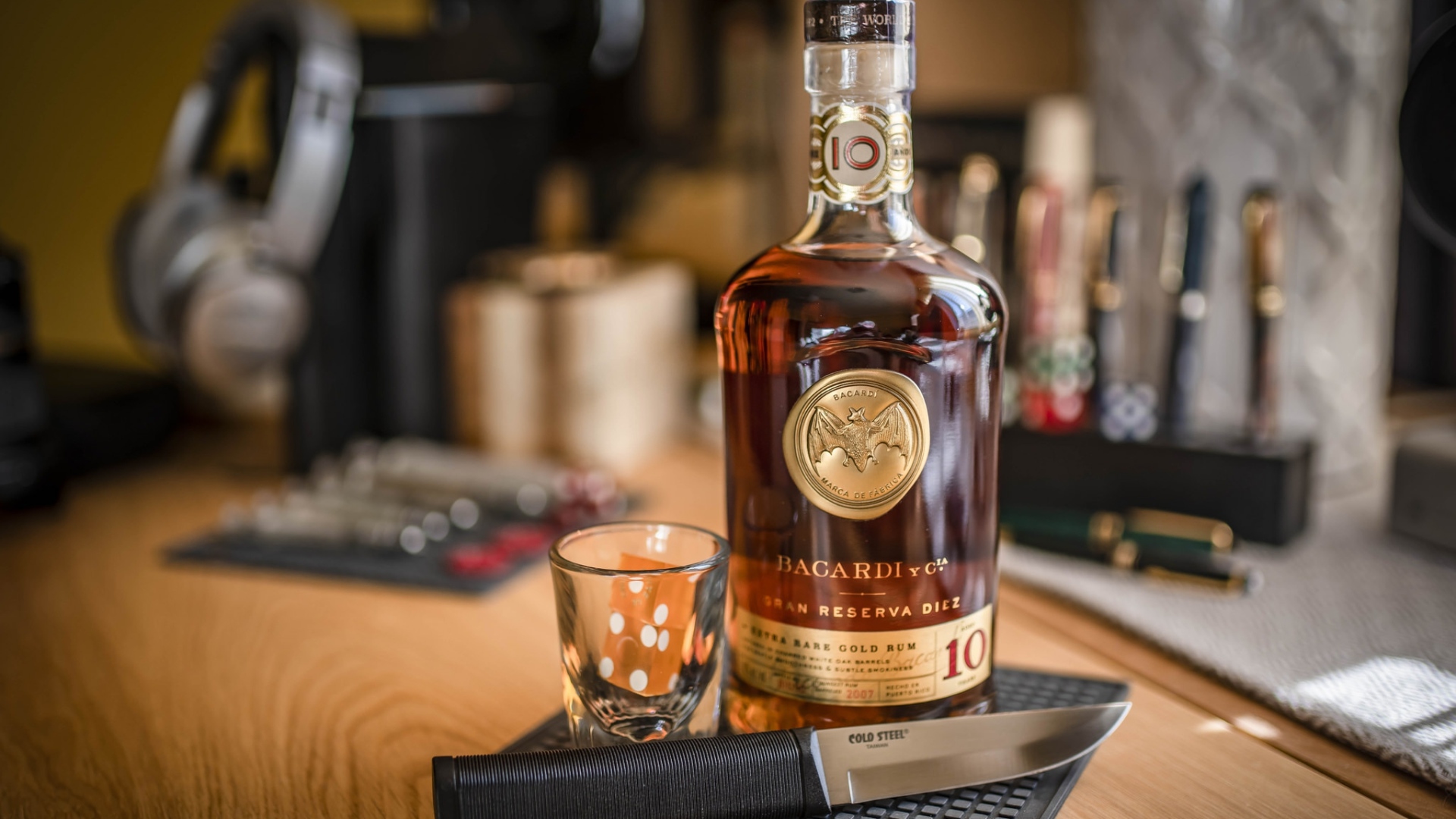 Бутылка виски на столе с рюмкой и ножом