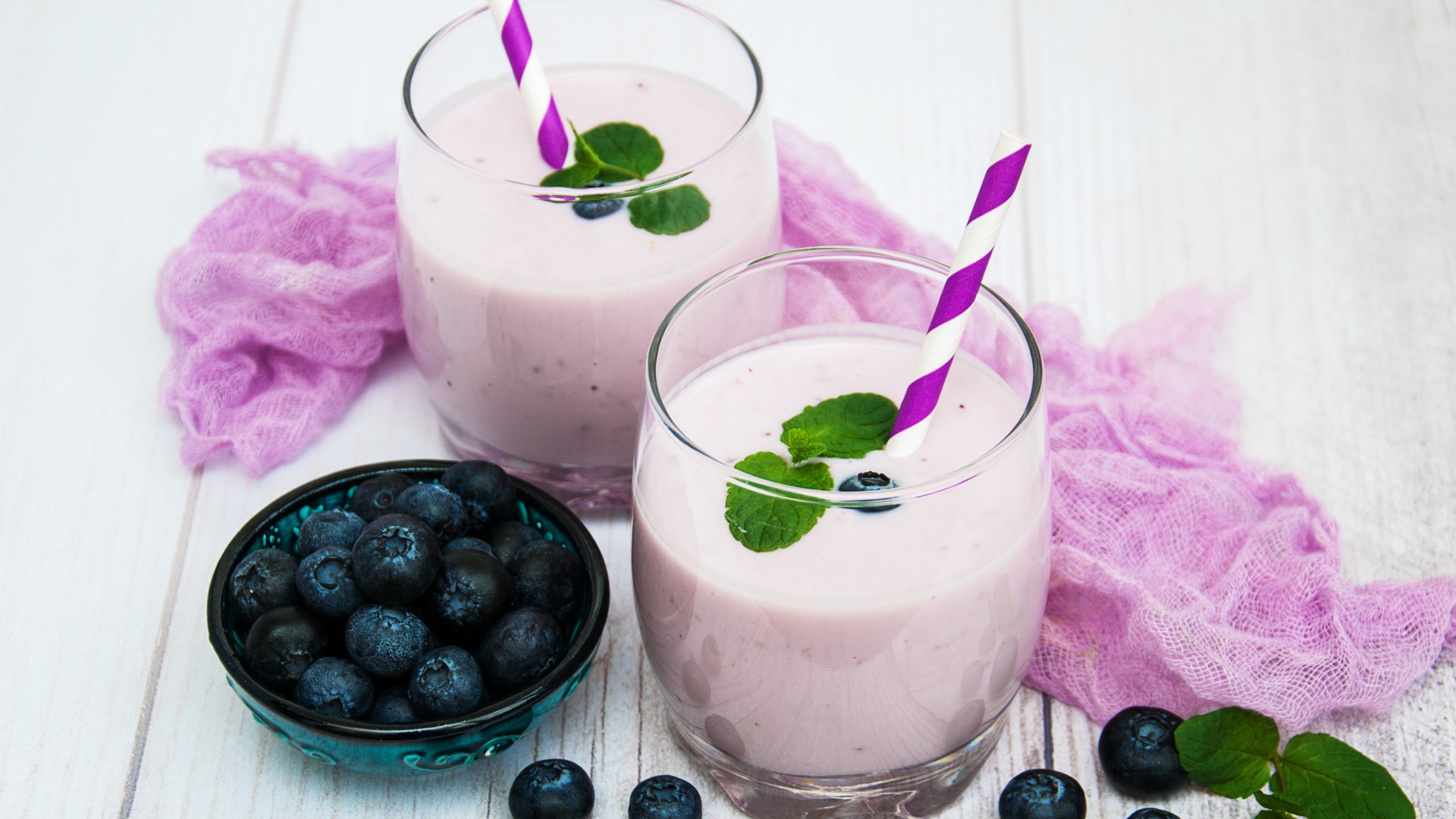 Коктейль в стаканах на столе с ягодами черники