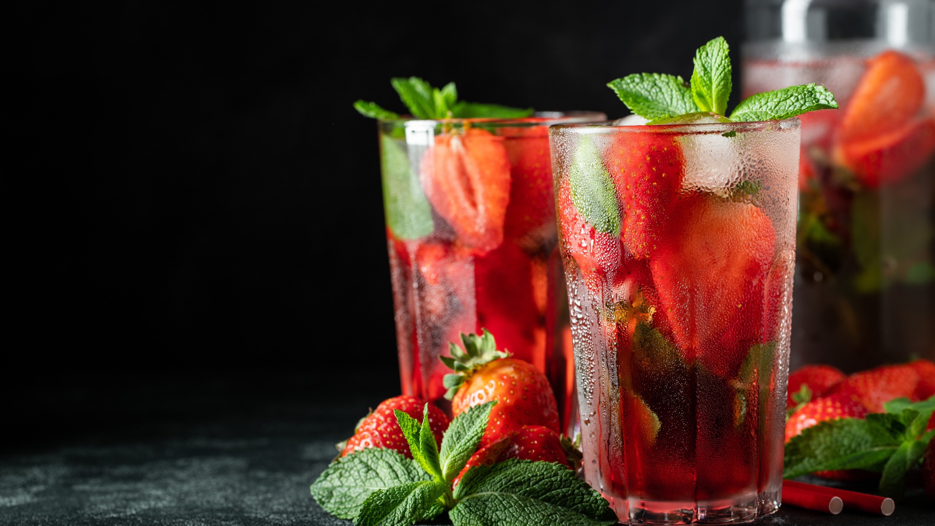 Холодный напиток в стакане на столе с клубникой и мятой