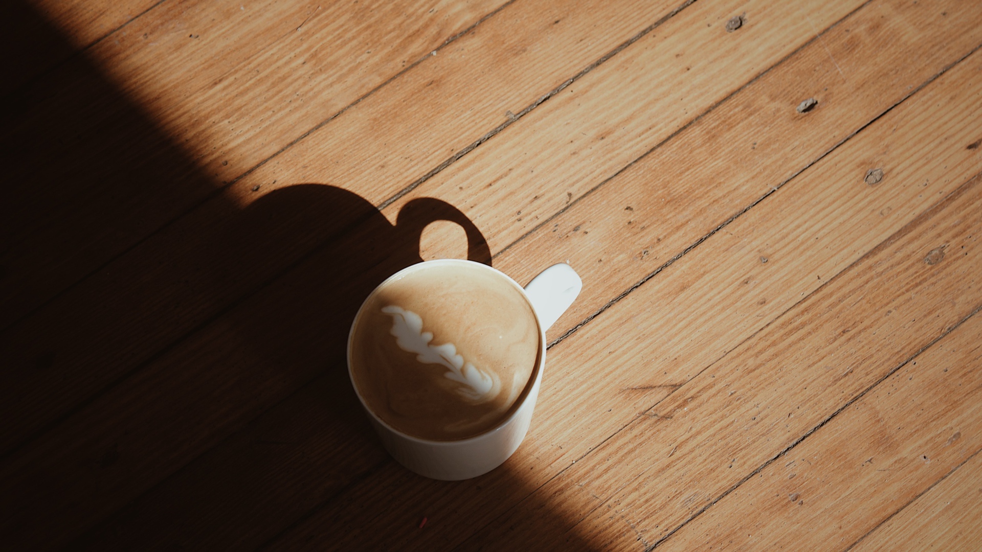 Чашка капучино с рисунком на деревянном столе