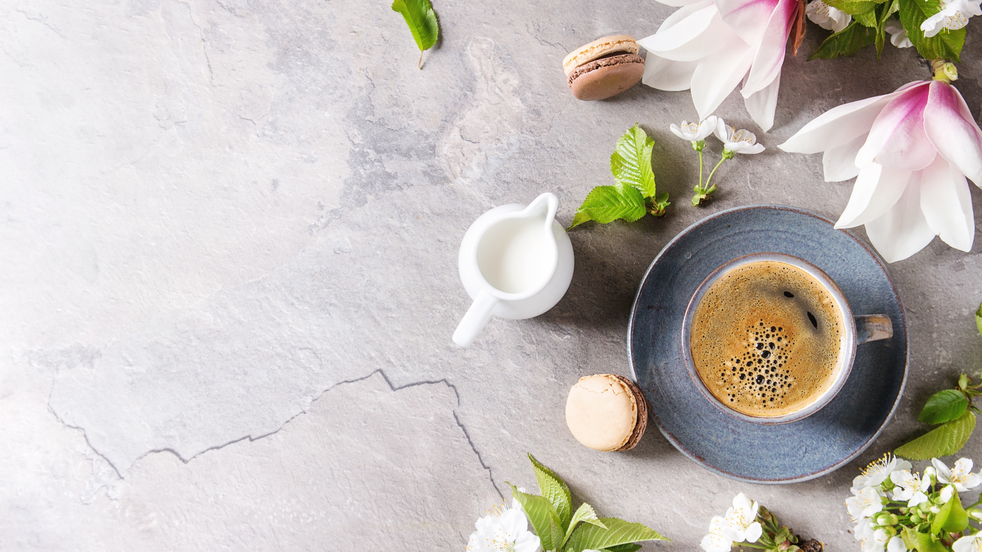 Чашка кофе на сером фоне с цветами вишни и магнолии