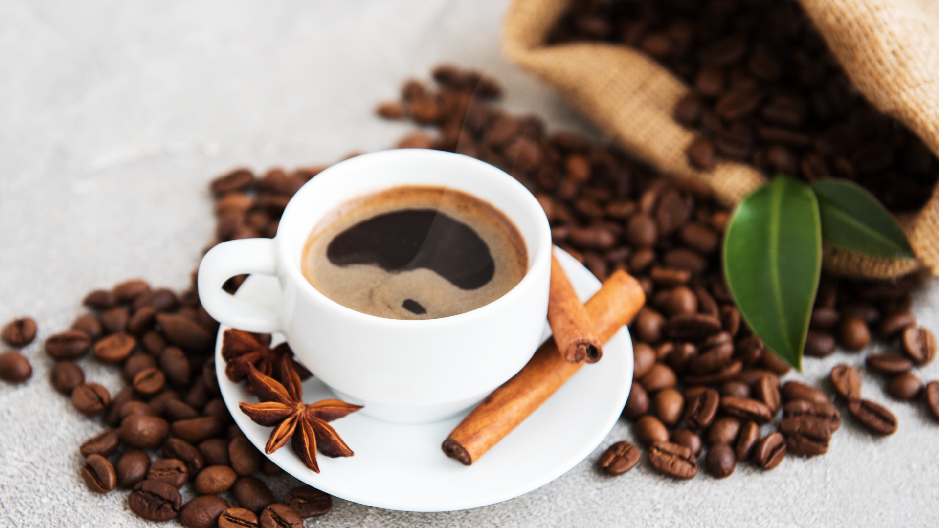 Чашка кофе с корицей, бадьяном и кофейными зернами
