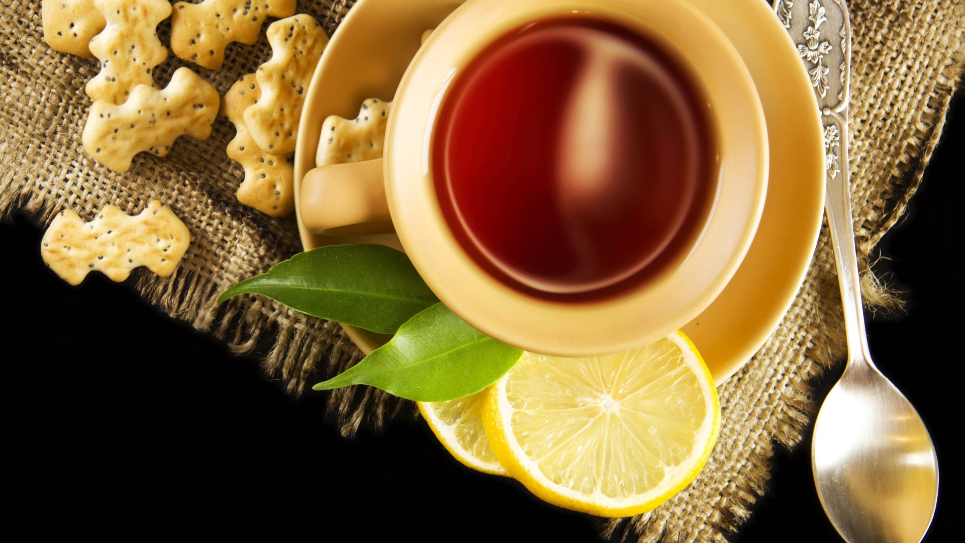 Чай на столе с печеньем и кусочками лимона