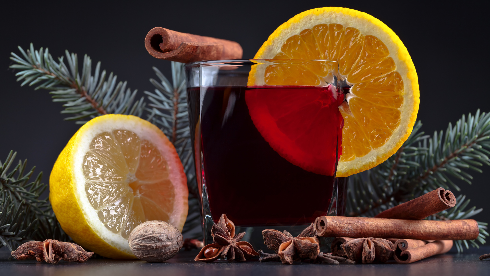 Чай с лимоном, корицей и бадьяном на сером фоне с еловой веткой