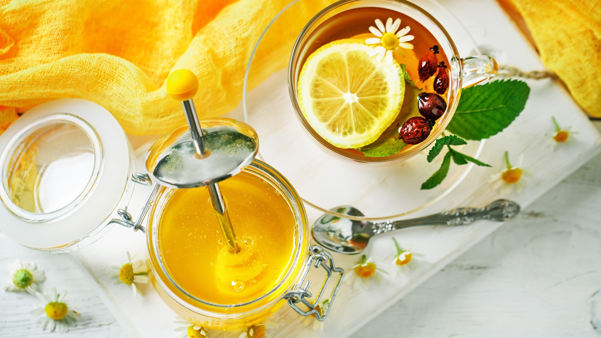 Чай с лимоном и шиповником на столе с медом