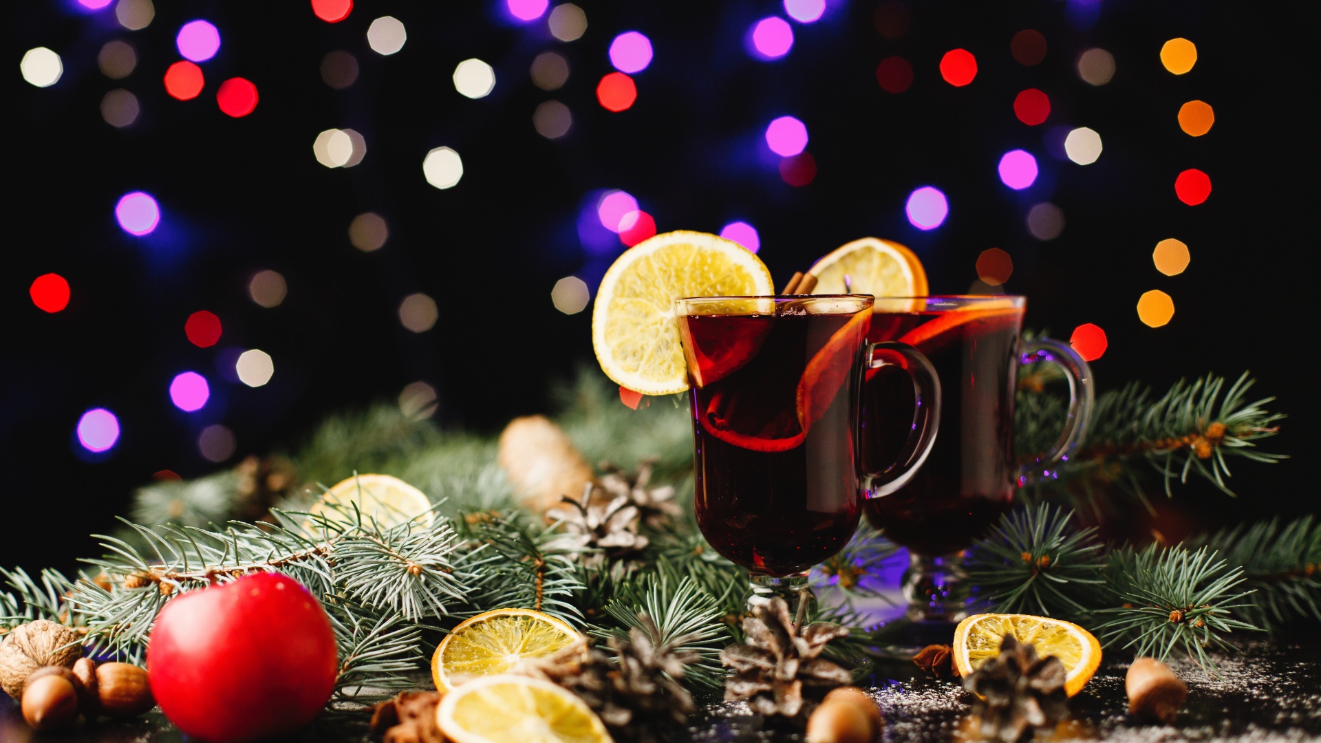 Два стакана глинтвейна на столе еловыми ветками 
