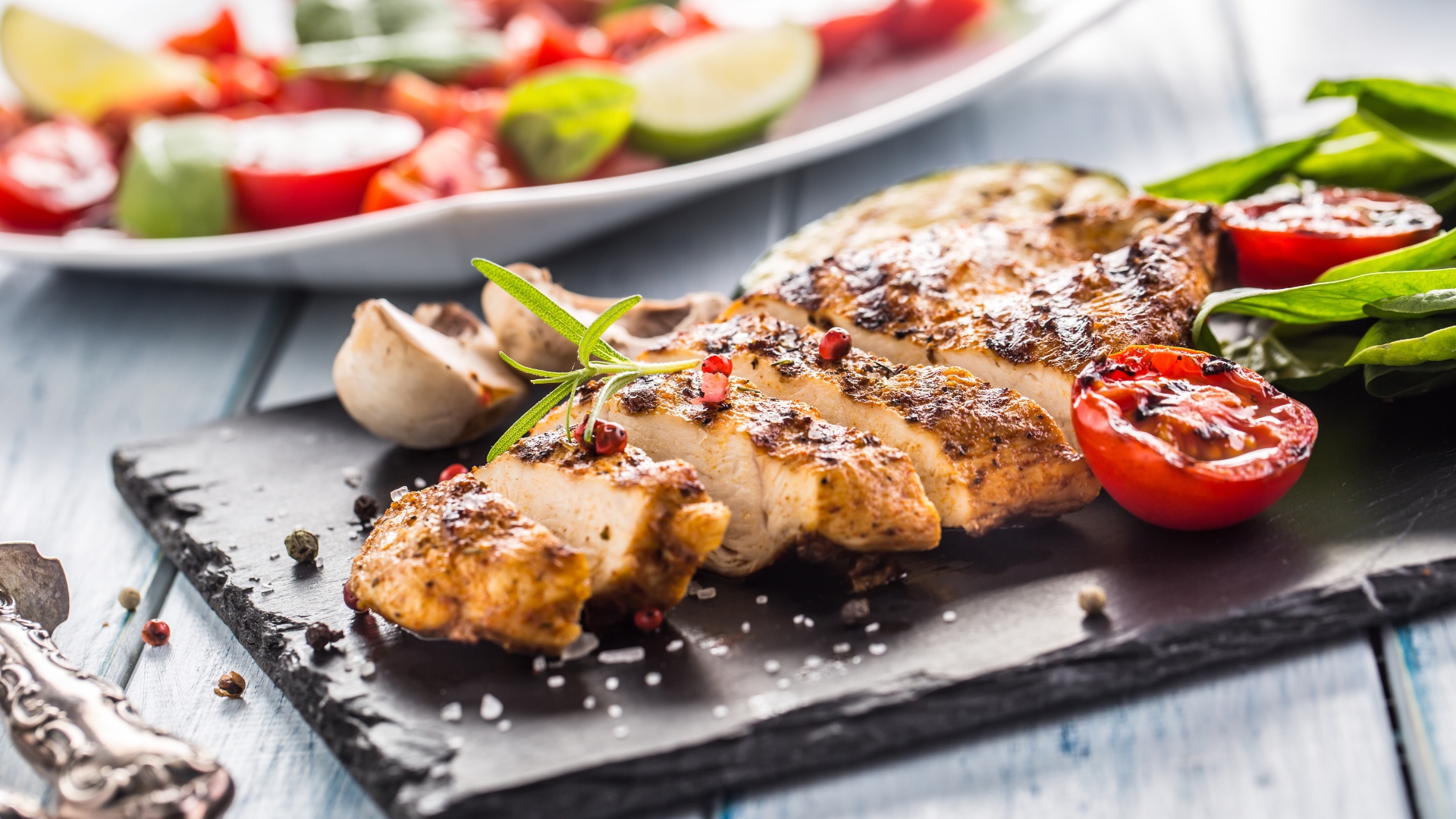 Запеченное куриное мясо на доске с помидорами 