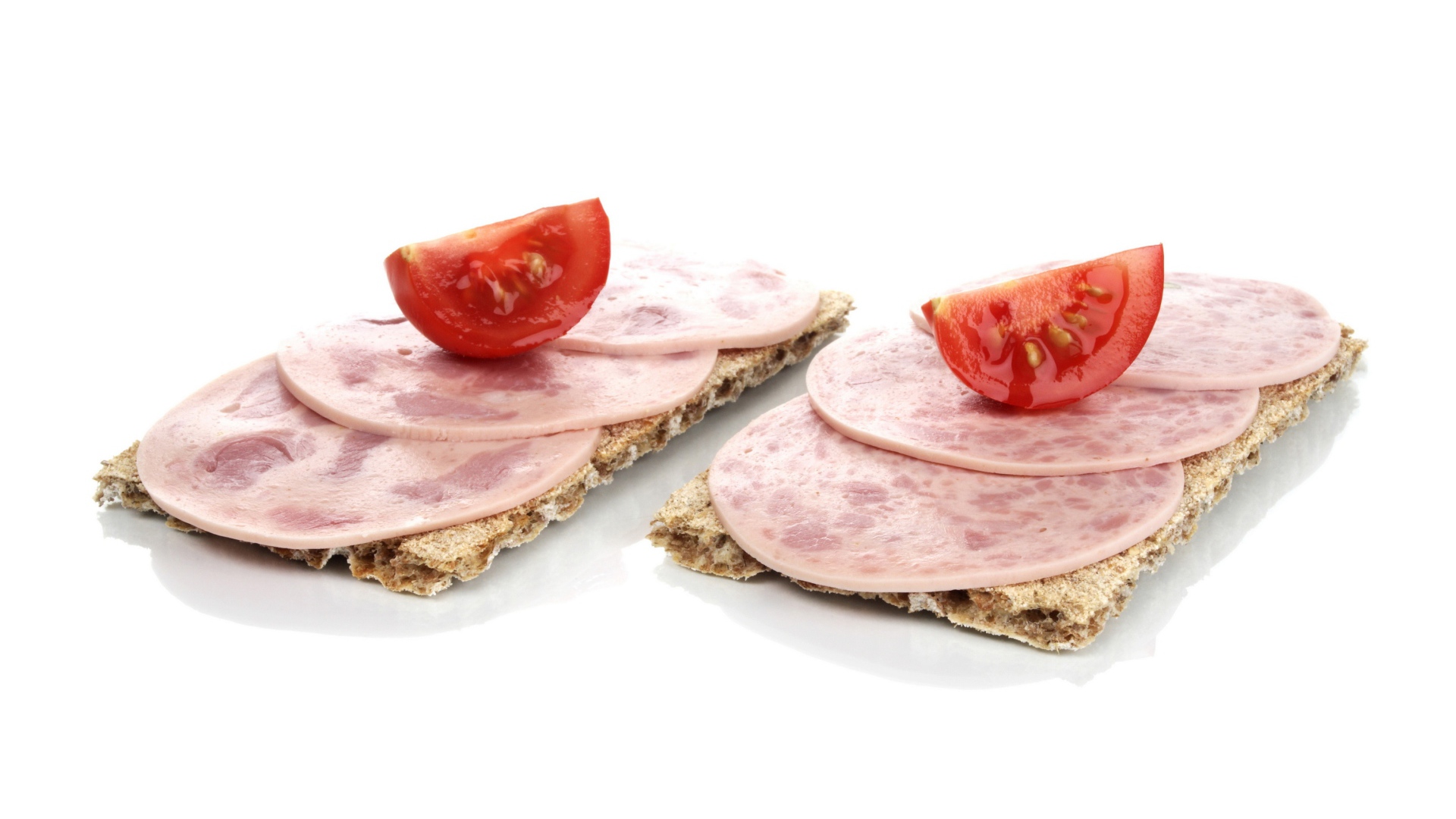 Тосты с колбасой и кусочками помидора на белом фоне