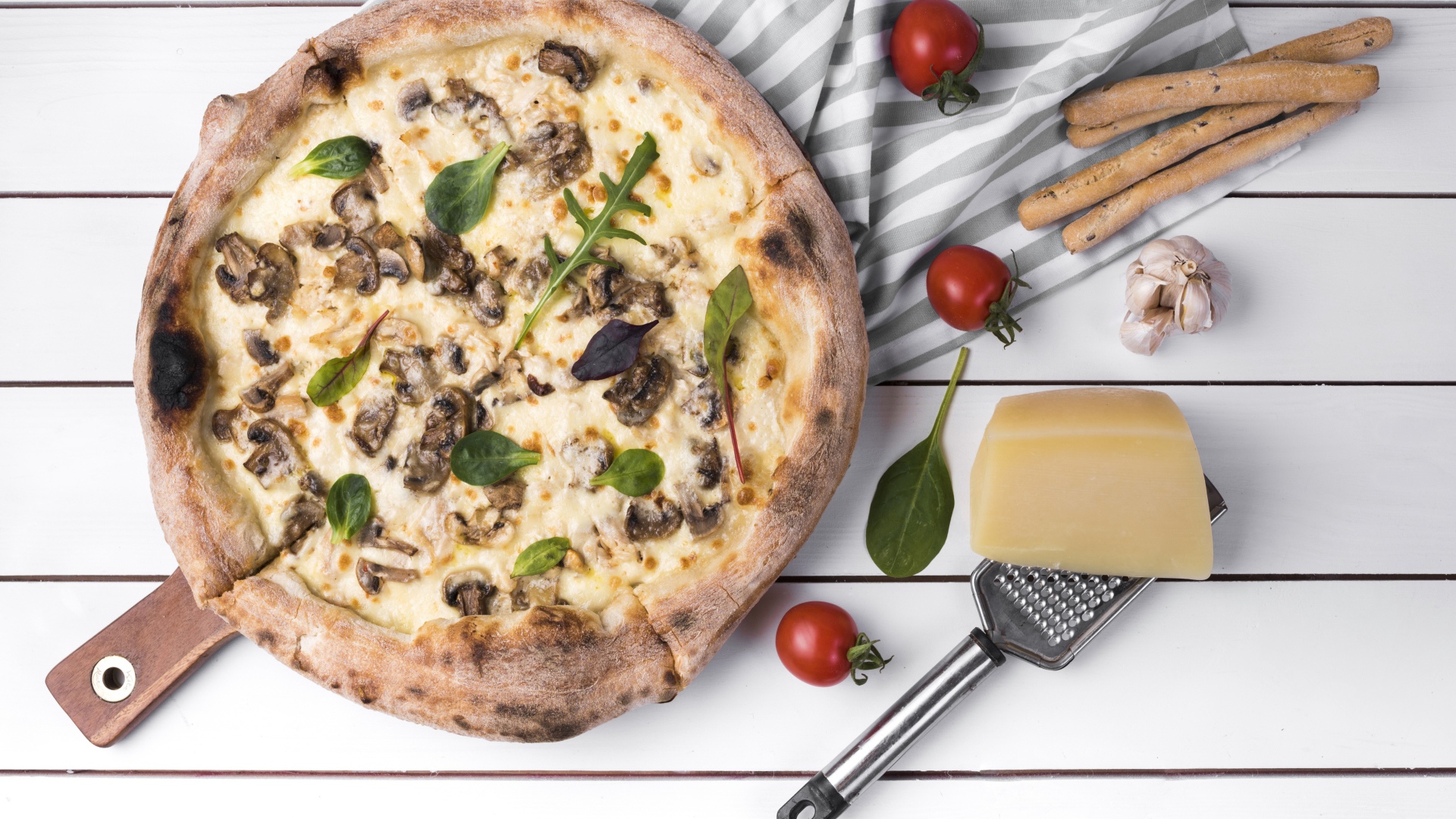Пицца с грибами на столе с сыром и овощами