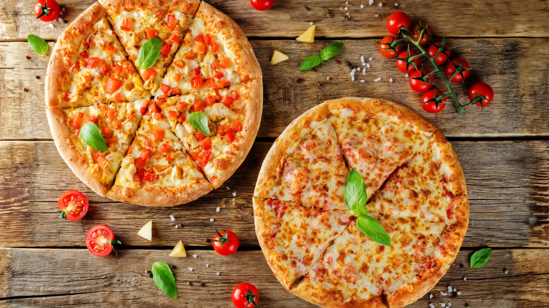 Две пиццы с сыром и болгарским перцем на столе с помидорами