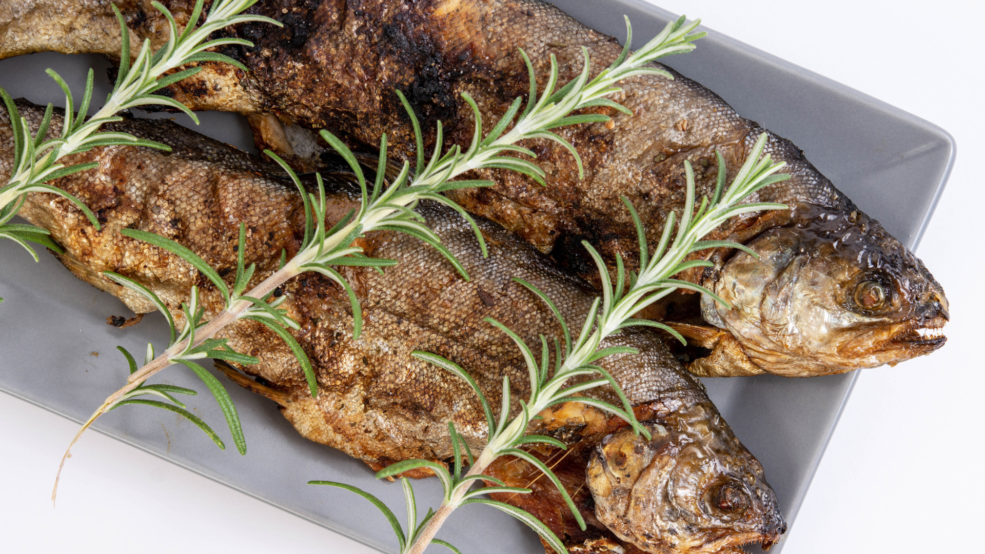 Baked fish with rosemary in a baking sheet