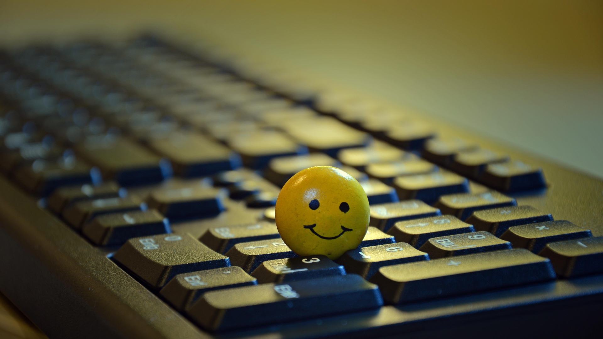 Желтый смайлик на черной клавиатуре 