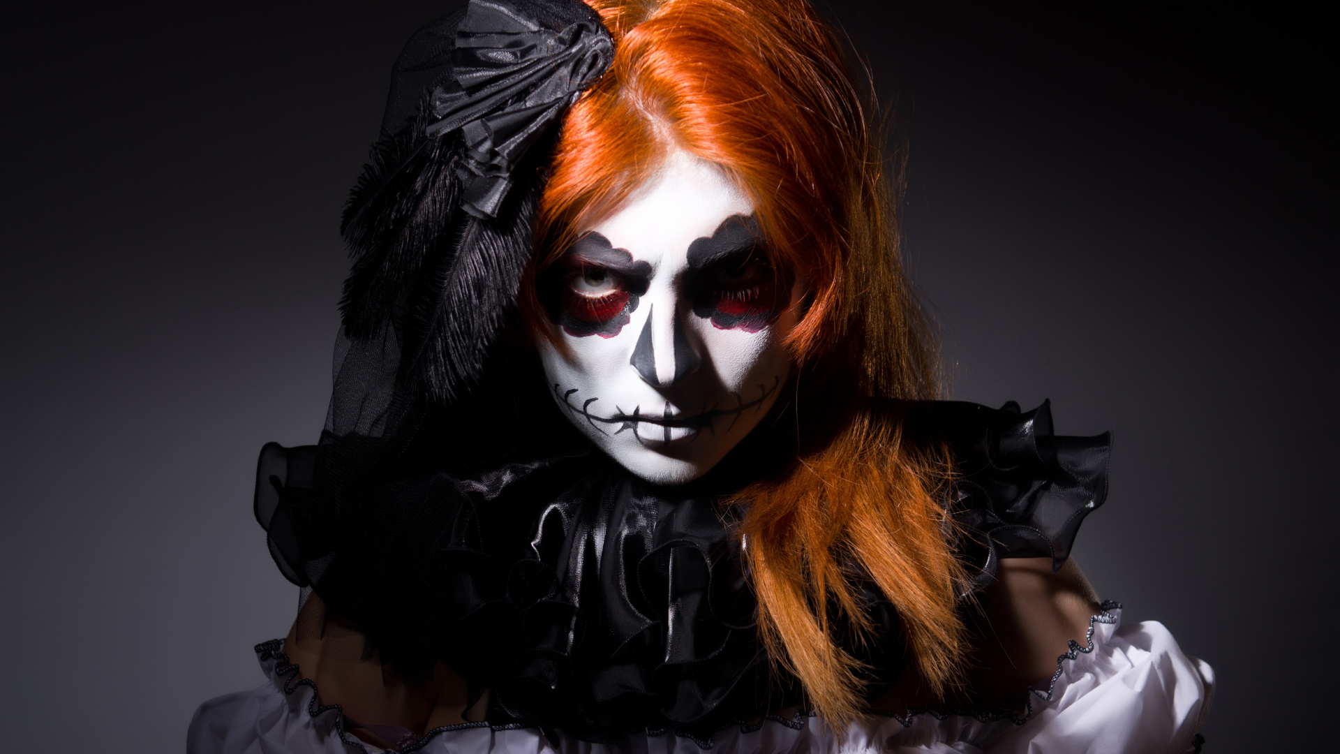 Рыжеволосая девушка с маской на лице на Хэллоуин 