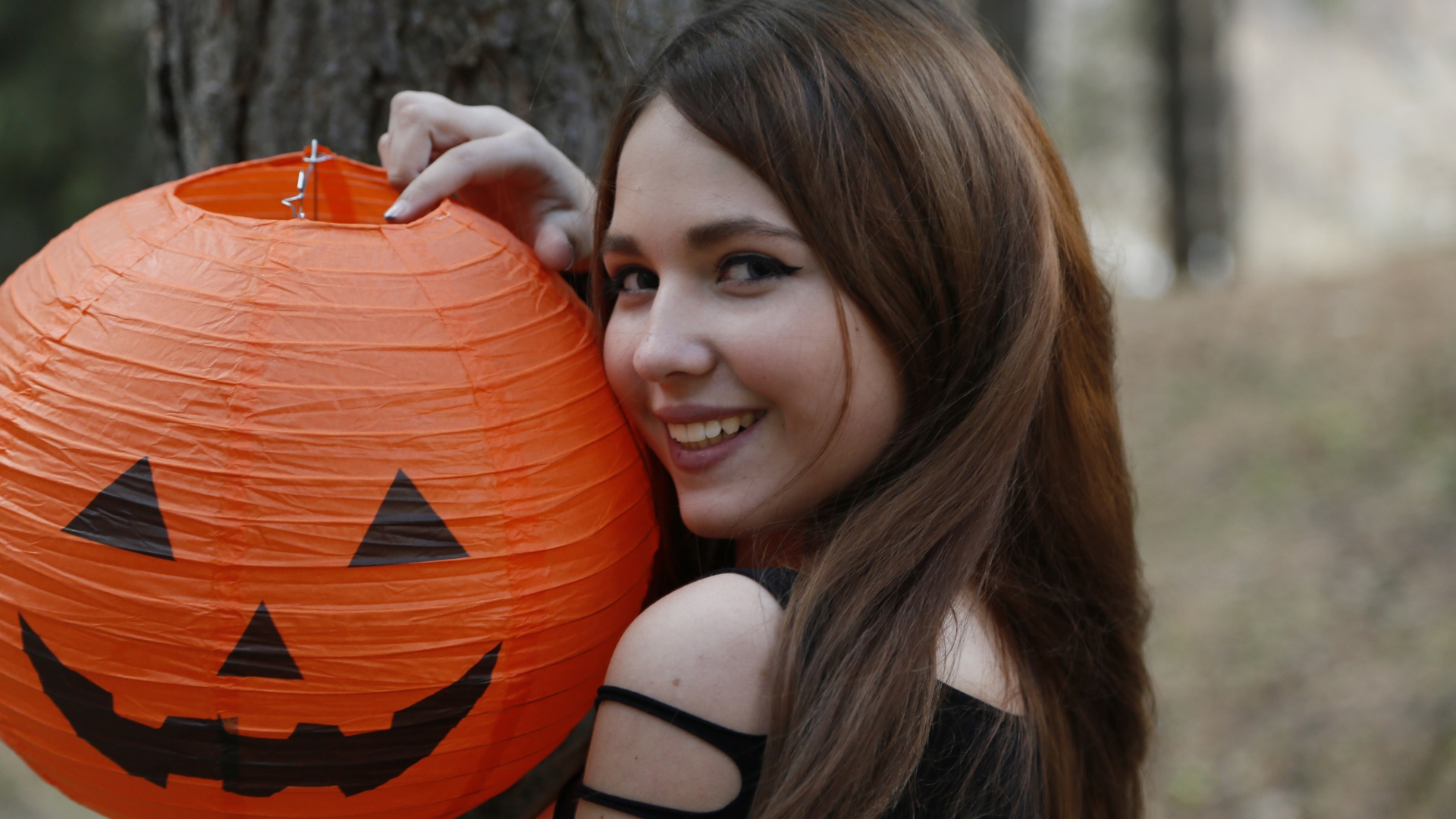 Улыбающаяся девушка с декором на праздник Хэллоуин