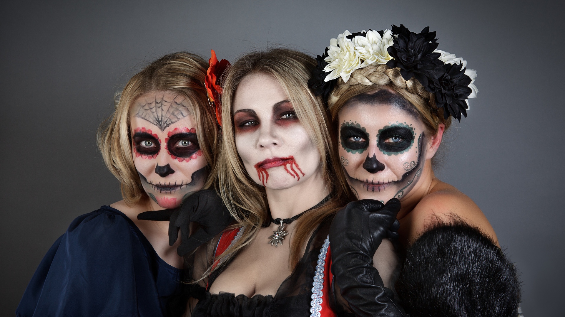 Три девушки с масками и в костюмах на Хэллоуин 