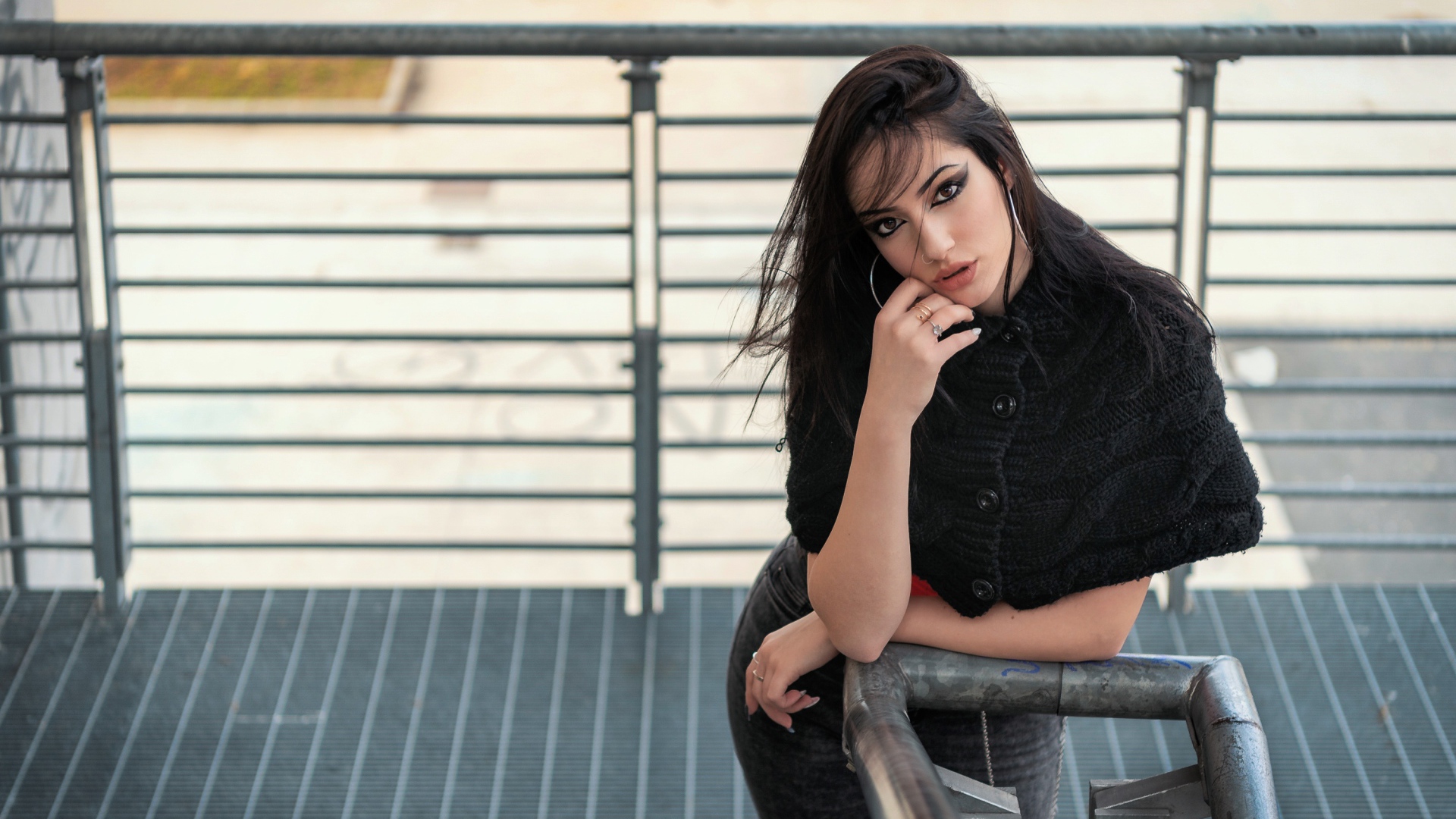 Красивая девушка стоит на ступеньках у перил 