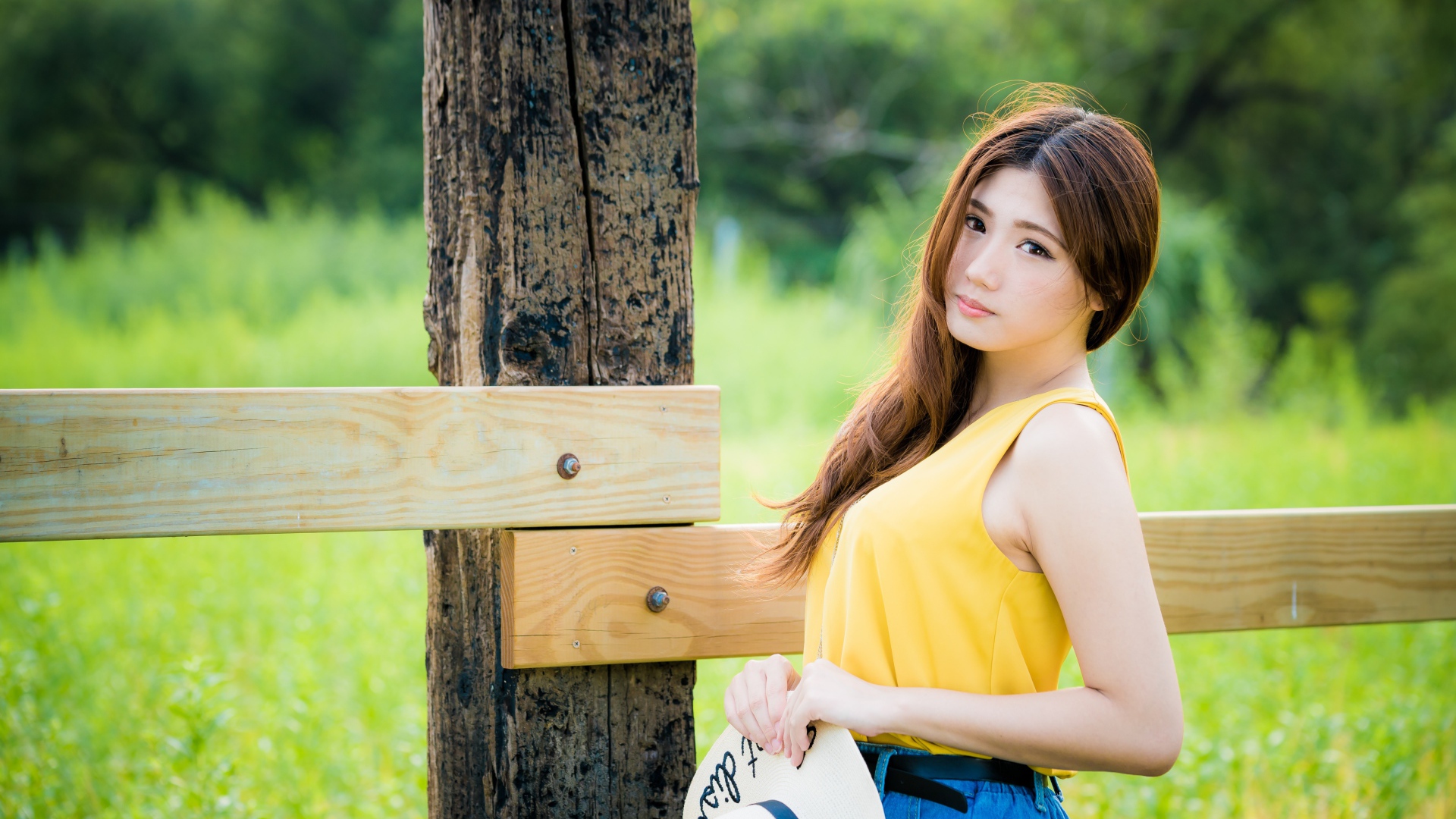 Красивая азиатка у деревянного столба 